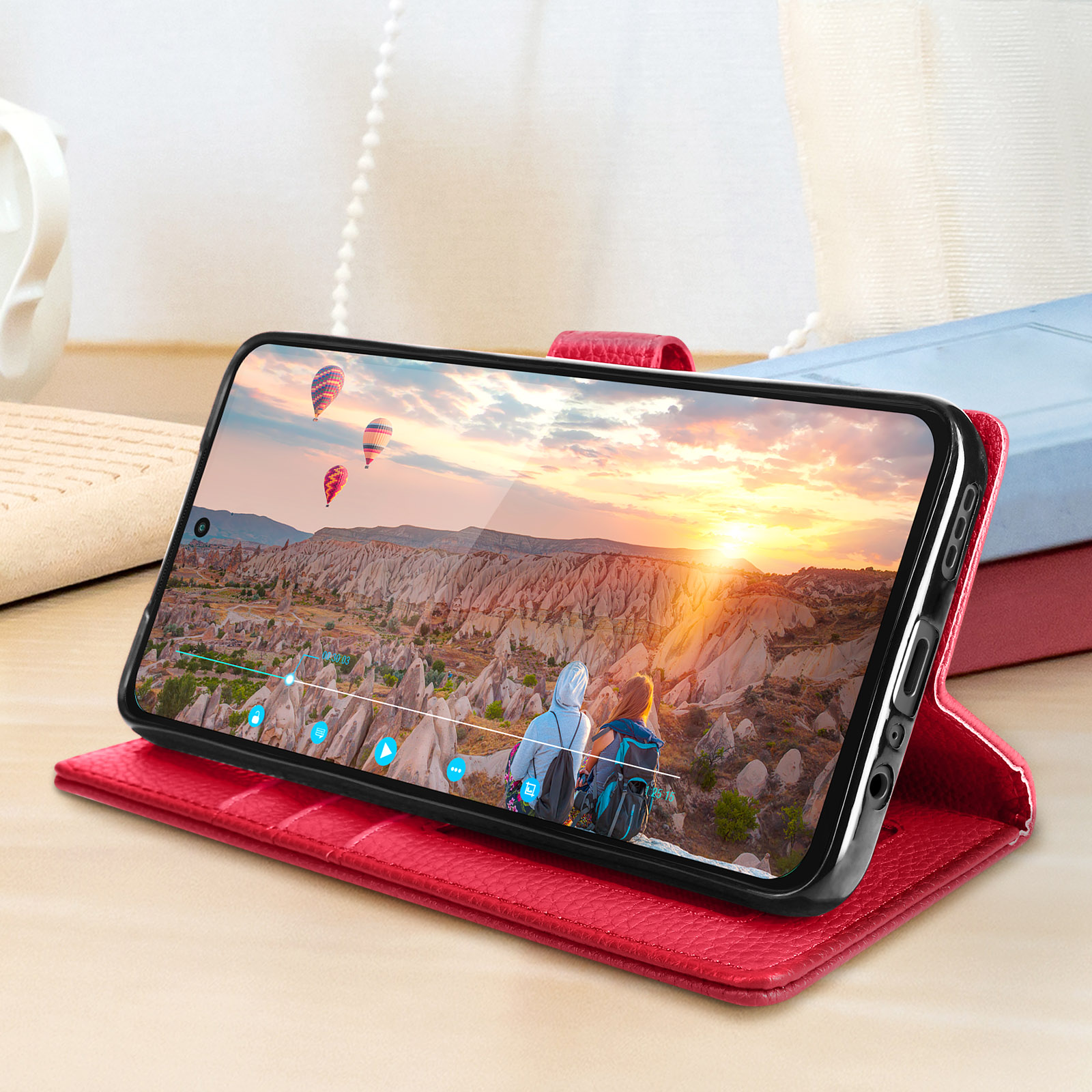 Un telefono che mostra una scena al tramonto, in una custodia di pelle rossa.