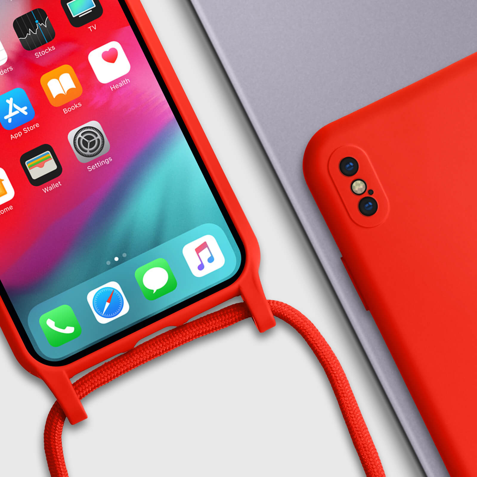 Un téléphone rouge avec un cordon, affichant des icônes d'applications, à côté d'une autre coque rouge.