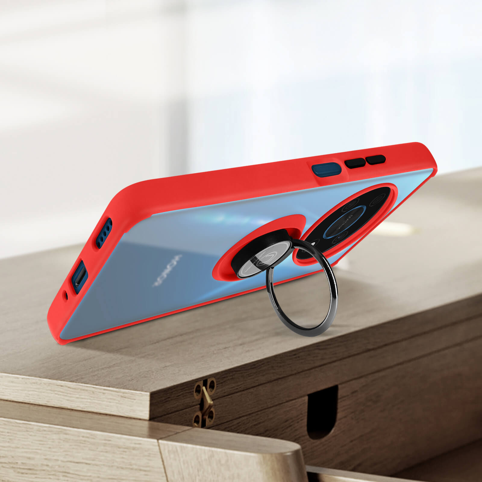 Un téléphone avec un support d'anneau, posé sur une surface en bois. L'étui est rouge.