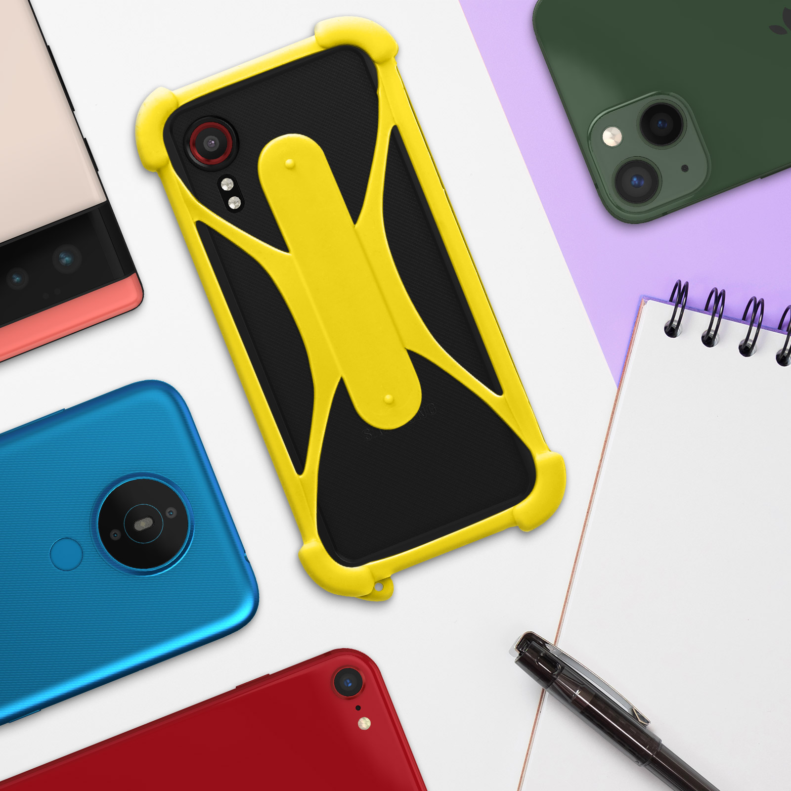 Diverses coques de téléphone sur une surface, avec un carnet et un stylo.
