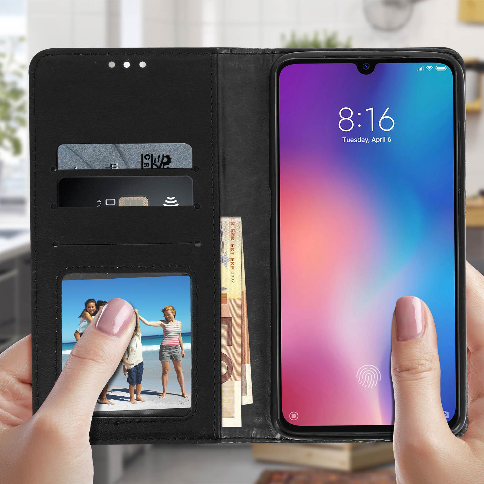 Mani che tengono un telefono in una custodia a portafoglio, mostrando una foto, denaro e carte di credito.