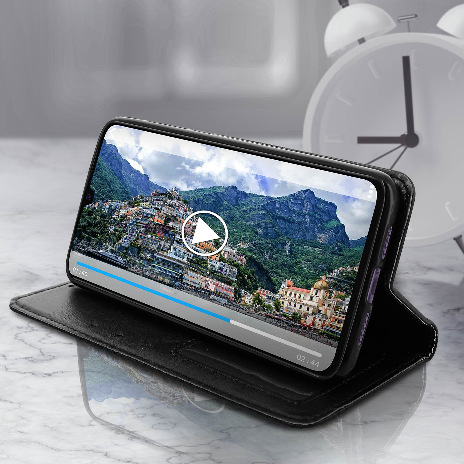Telefono in una custodia che mostra un video. Un orologio è visibile sullo sfondo.