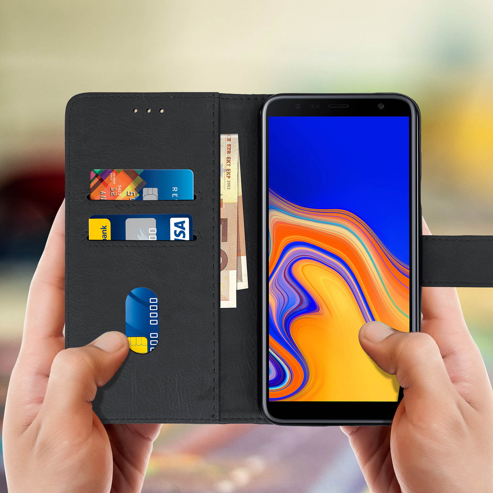 Mani che tengono un telefono in una custodia a portafoglio nera. Carte di credito e contanti all'interno. Schermo acceso.