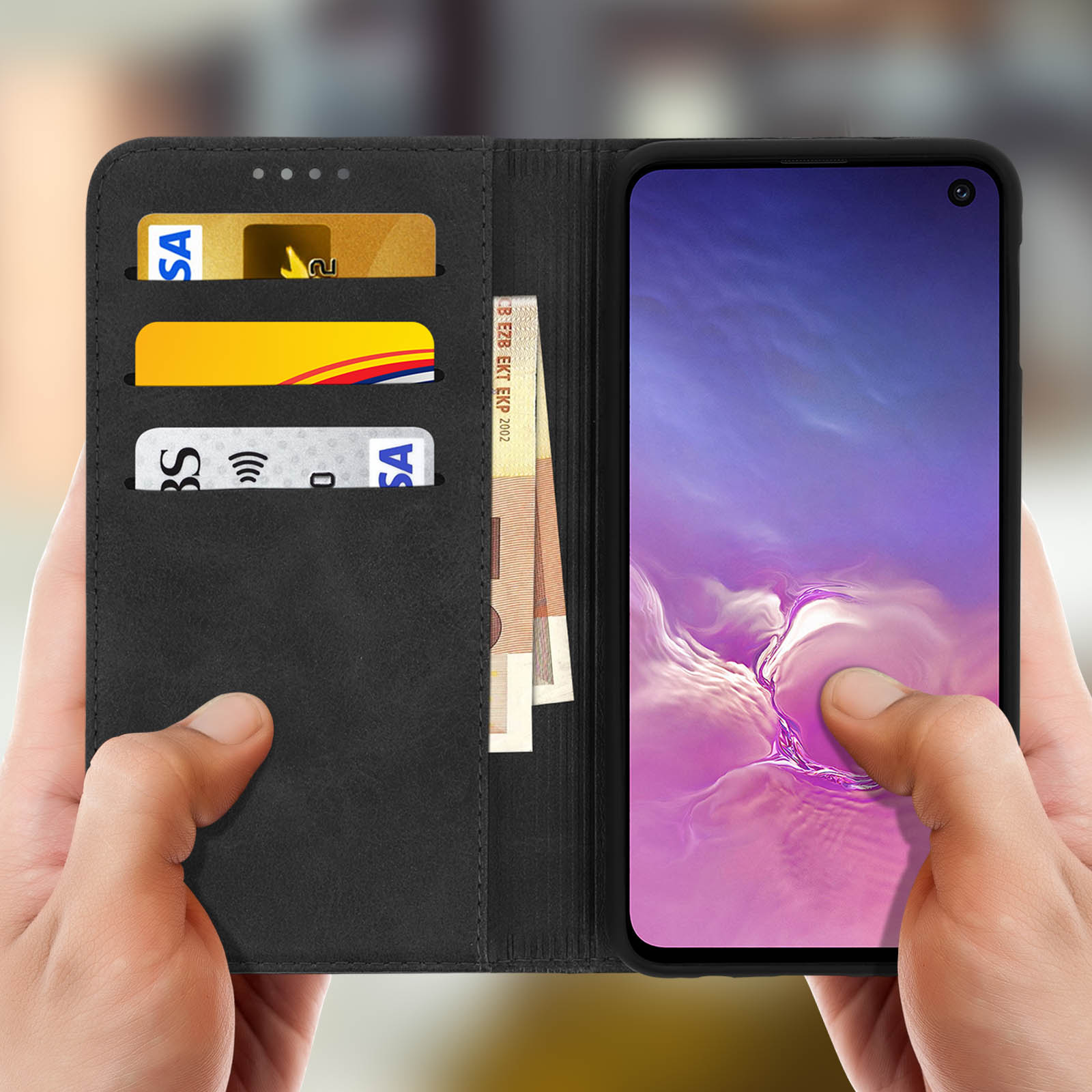 Mani che tengono una custodia nera per telefono con carte e contanti. Telefono visibile.