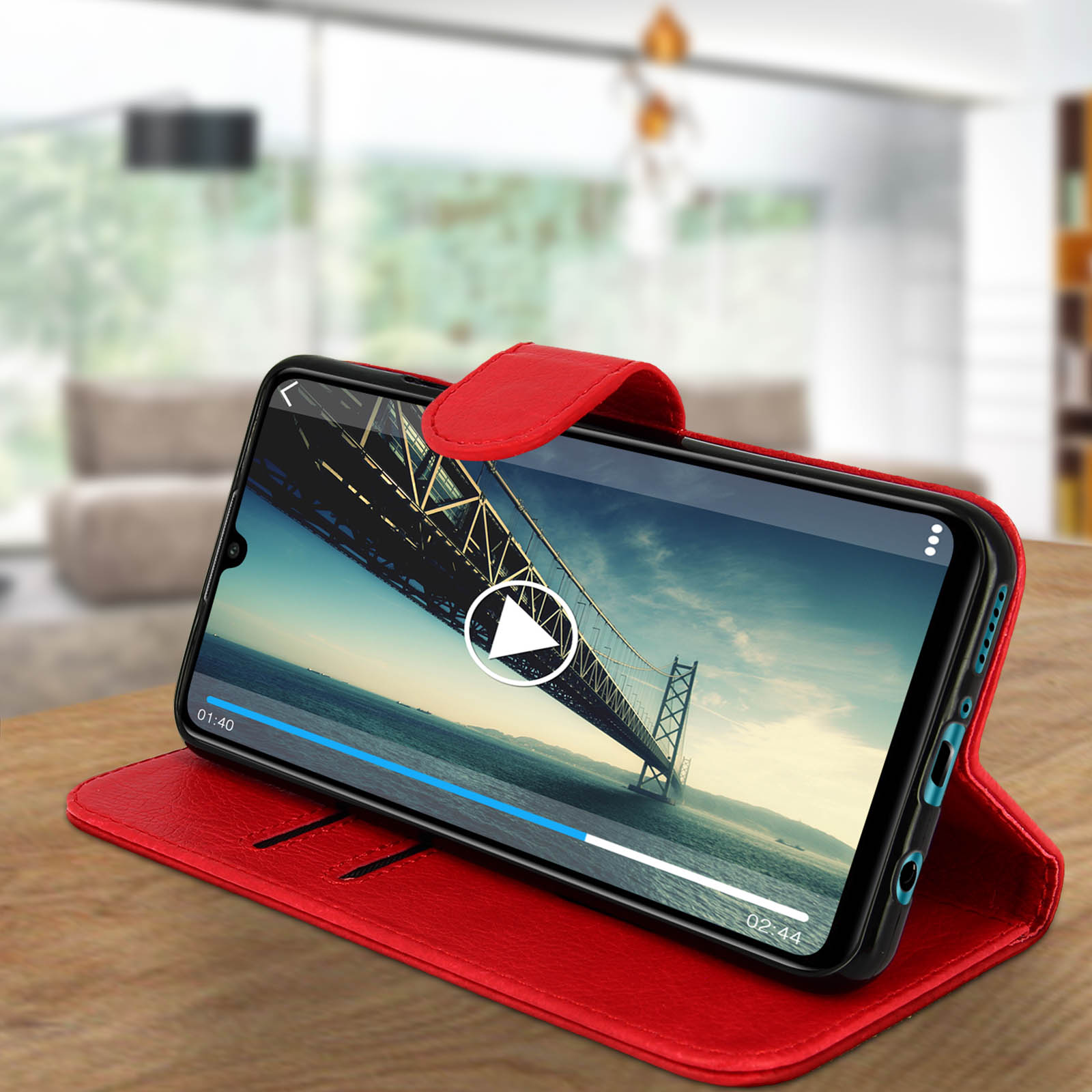 Custodia rossa con telefono. Il telefono mostra un video. La custodia è su un tavolo.