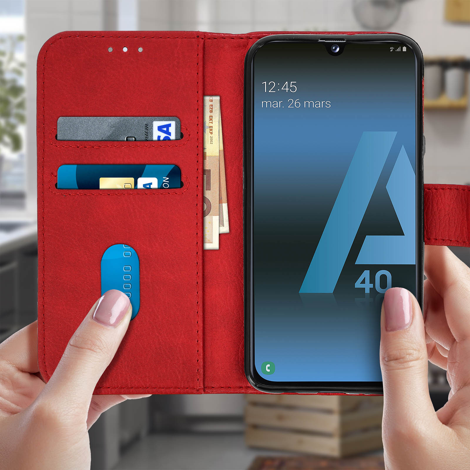 Mains tenant un étui de téléphone rouge ouvert, avec un téléphone affichant un écran avec des cartes de crédit et une horloge.