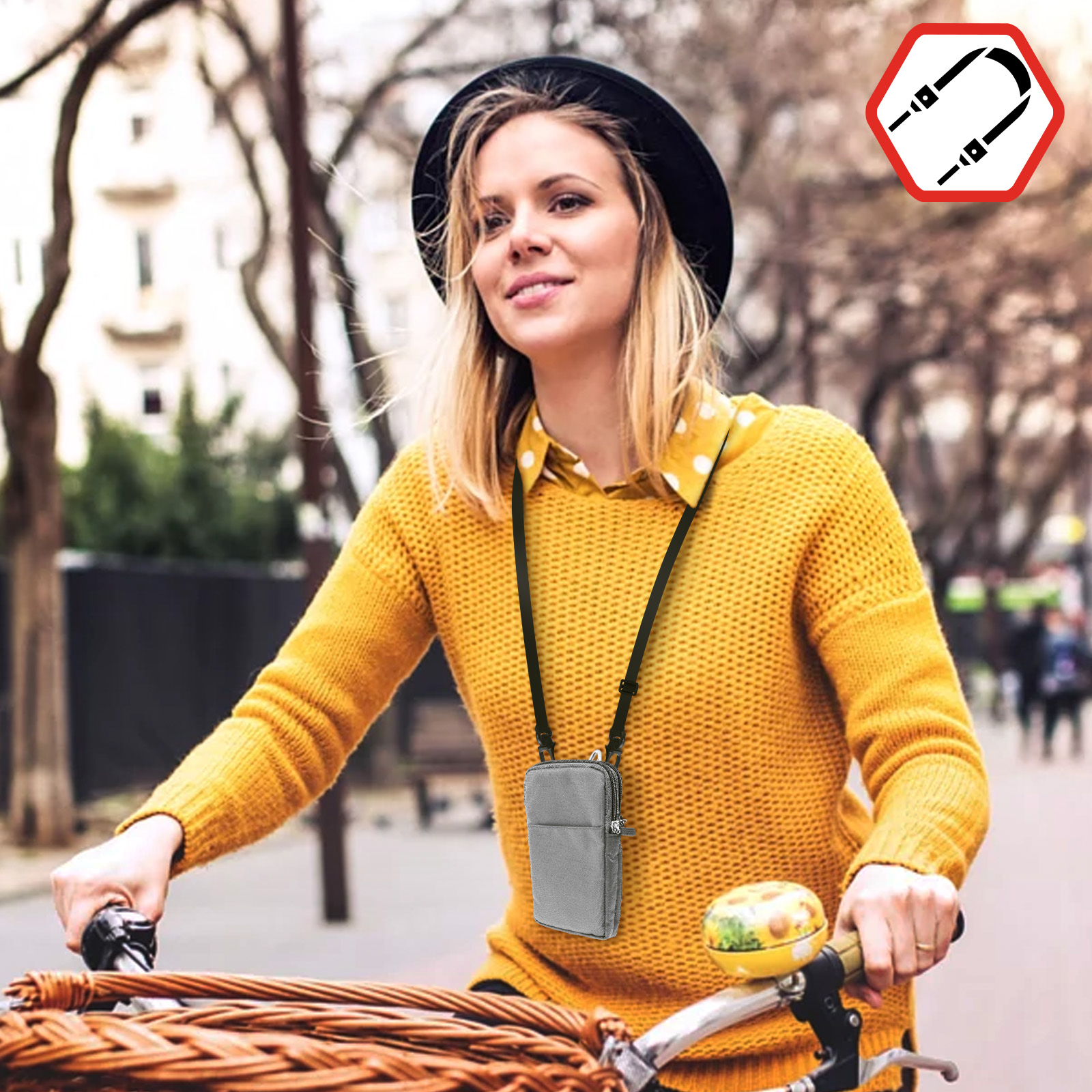 Donna in bicicletta, indossa un maglione giallo, borsa grigia con cinturino nero.