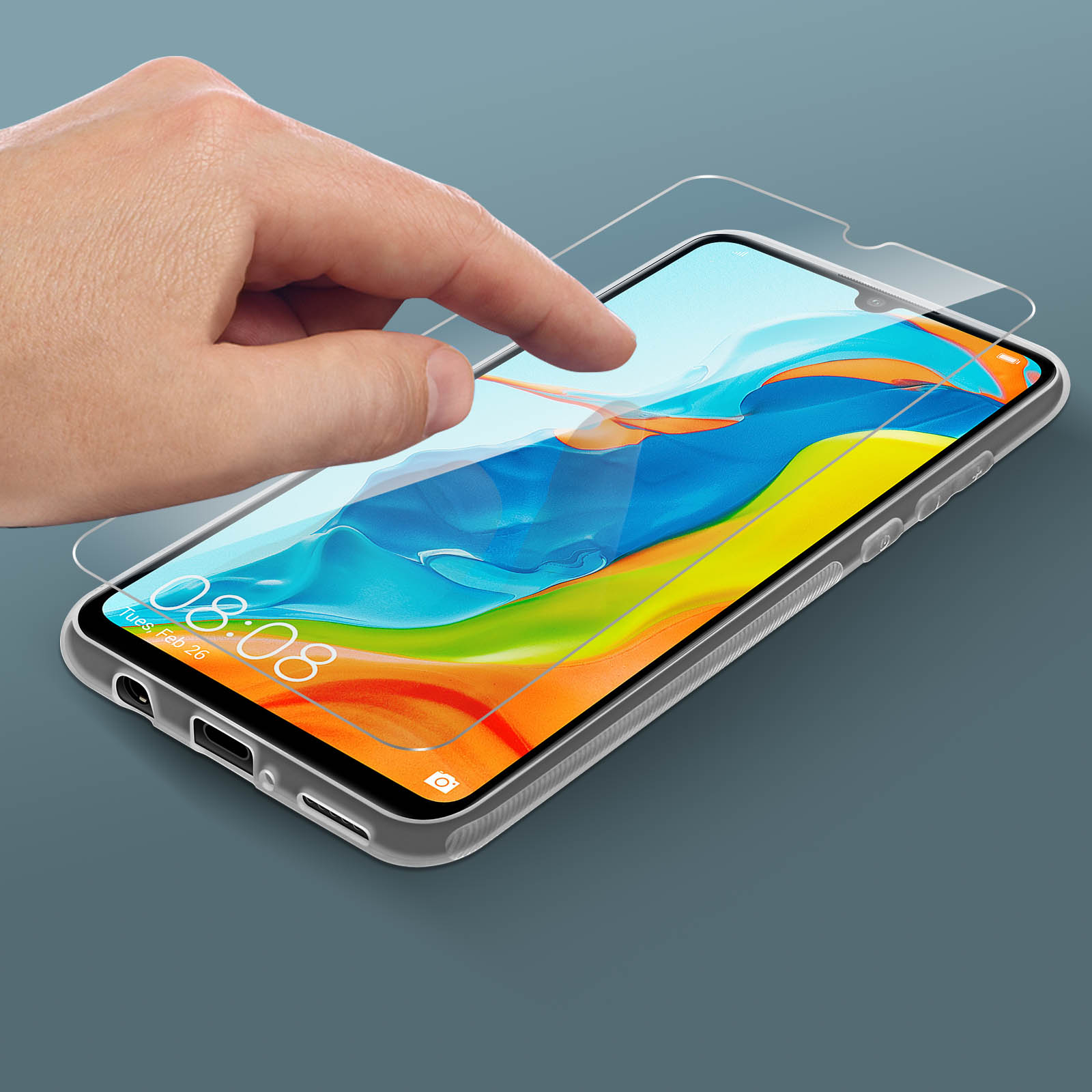 Una mano che applica una protezione per lo schermo a un telefono su una superficie grigia.