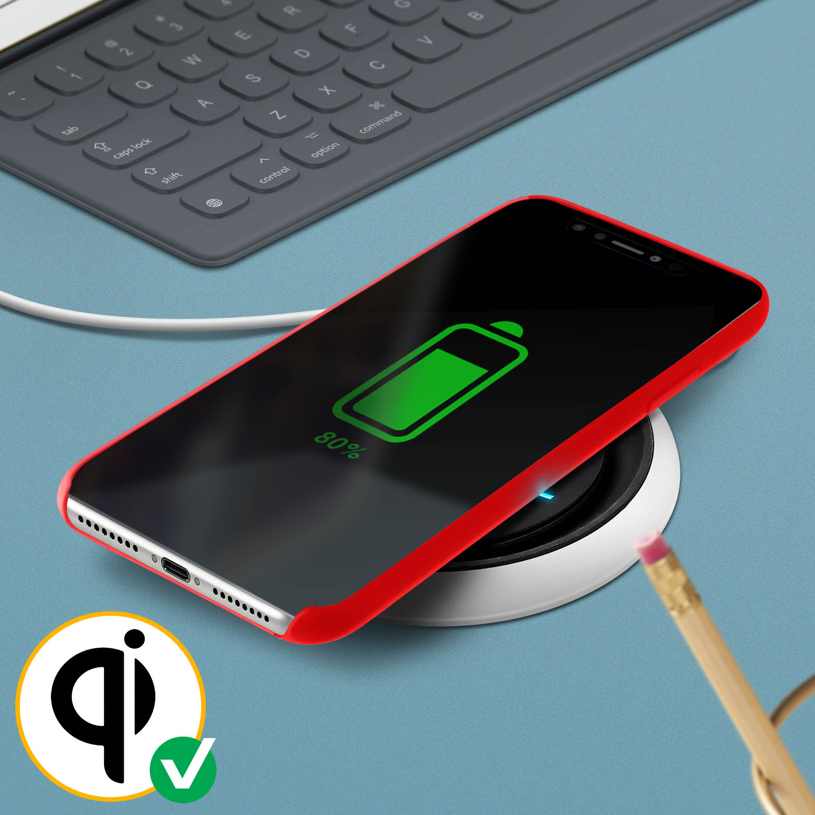 Telefono in carica wireless con icona batteria verde. Matita e caricatore visibili.