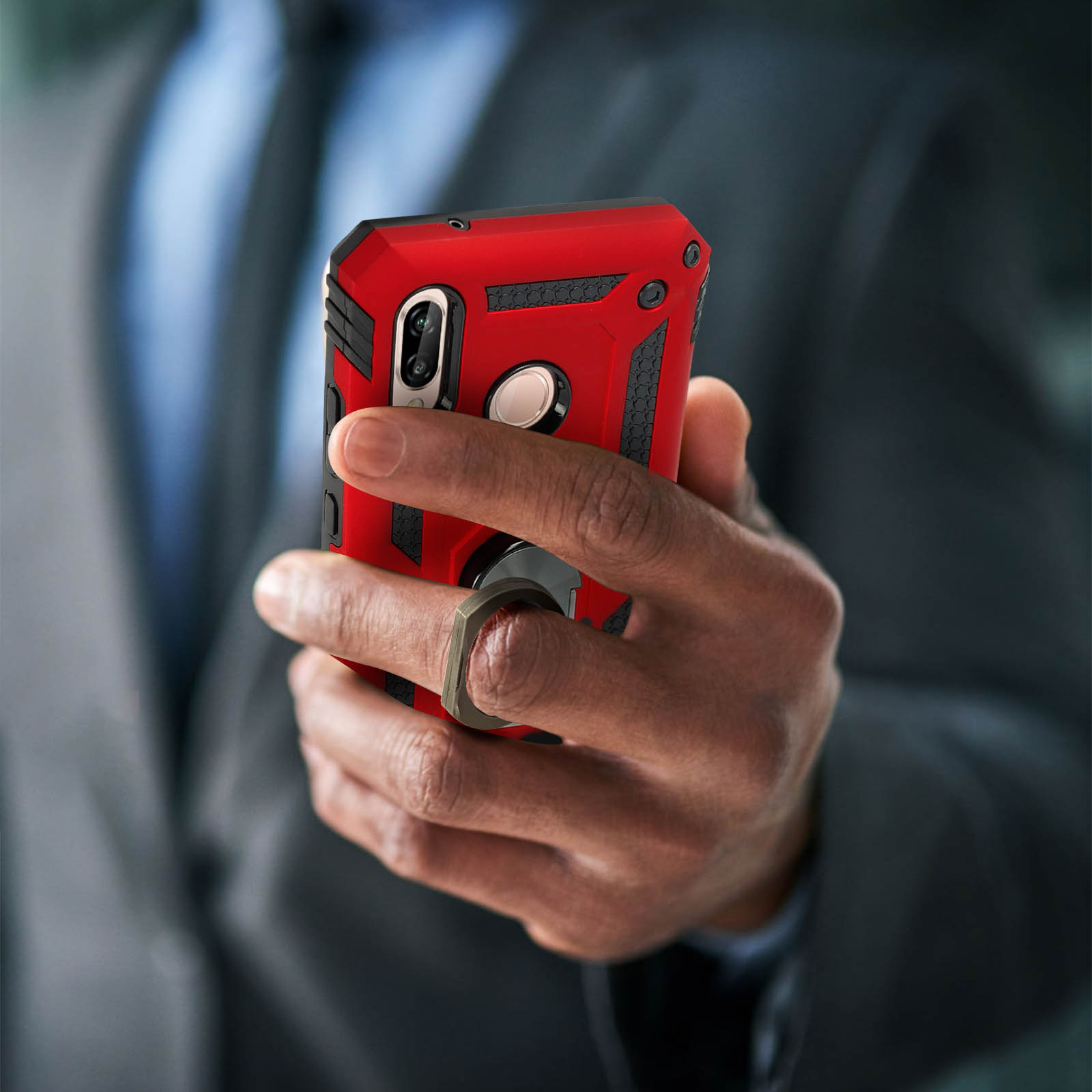 Main tenant une coque de téléphone rouge avec un support à anneau.