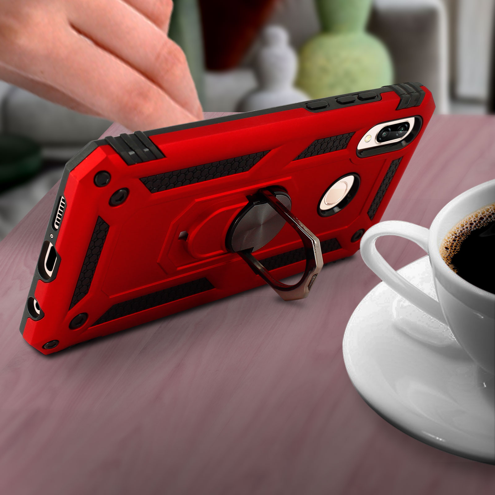 Un étui de téléphone rouge sur une table. Il a un anneau pour la prise et un téléphone à l'intérieur.