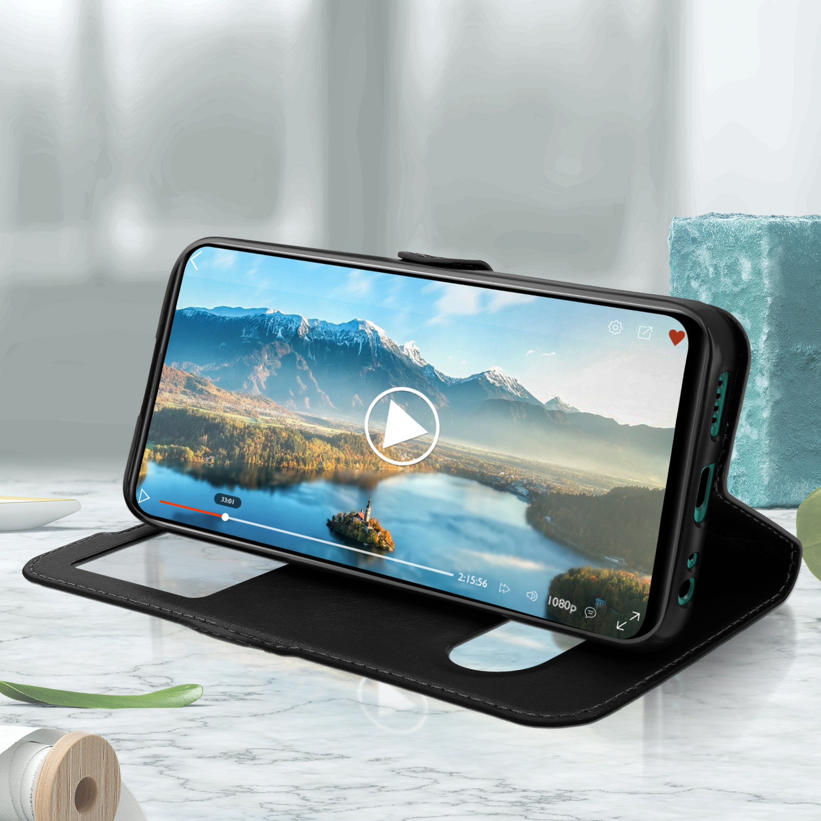 Una custodia per telefono nera con un telefono che mostra un video e una bobina di legno.