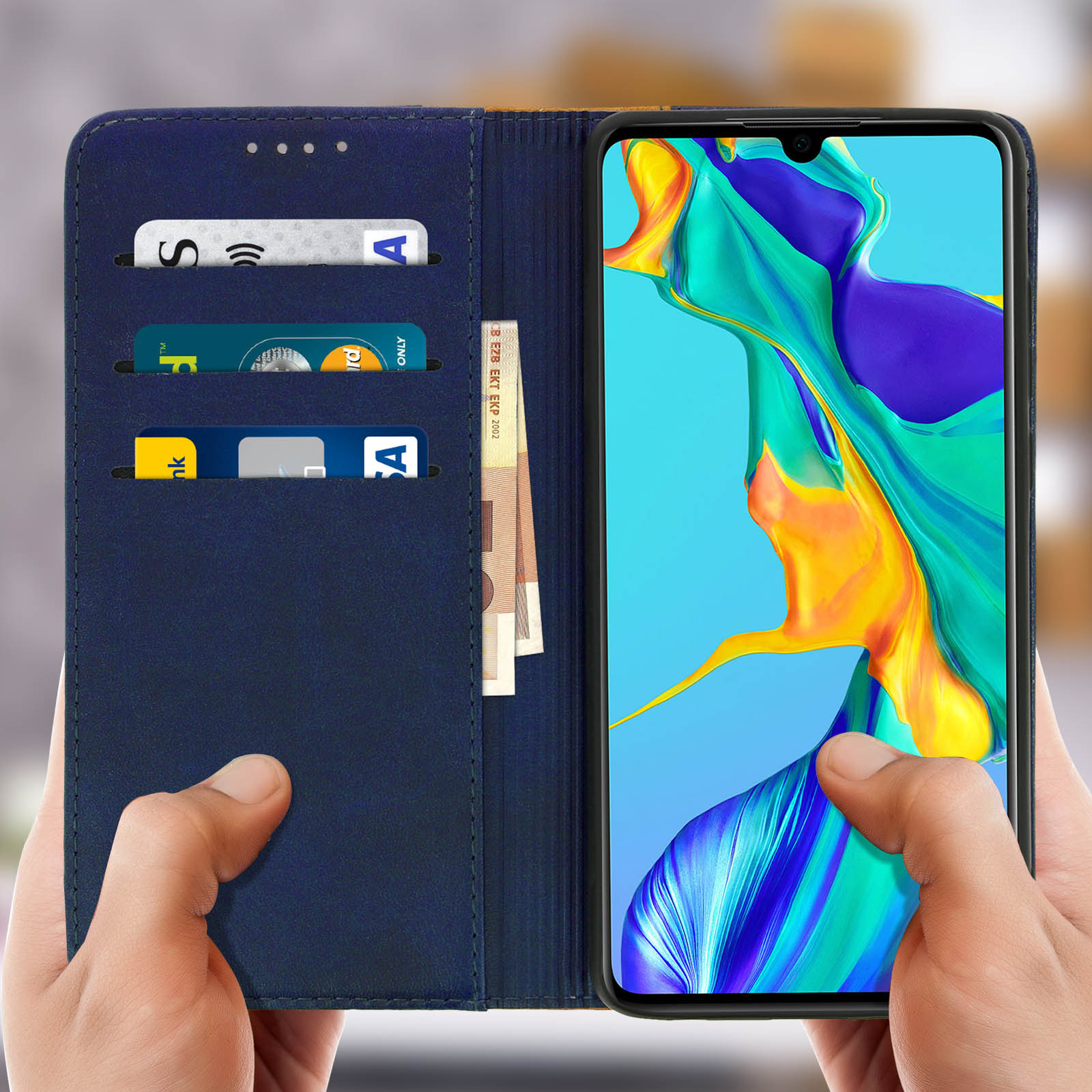 Mani che tengono aperta una custodia blu per telefono, rivelando carte e contanti all'interno.