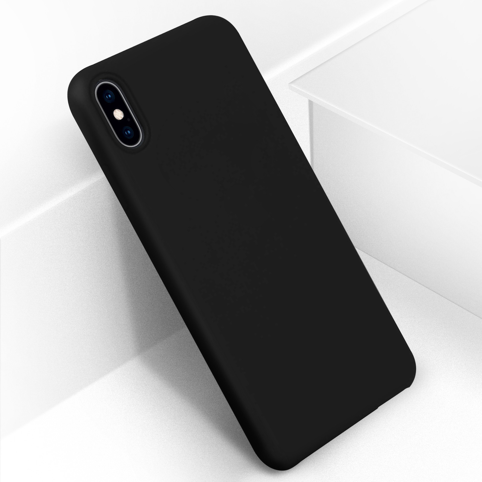Custodia nera per telefono su una superficie bianca. La custodia è elegante, con un ritaglio per la fotocamera.