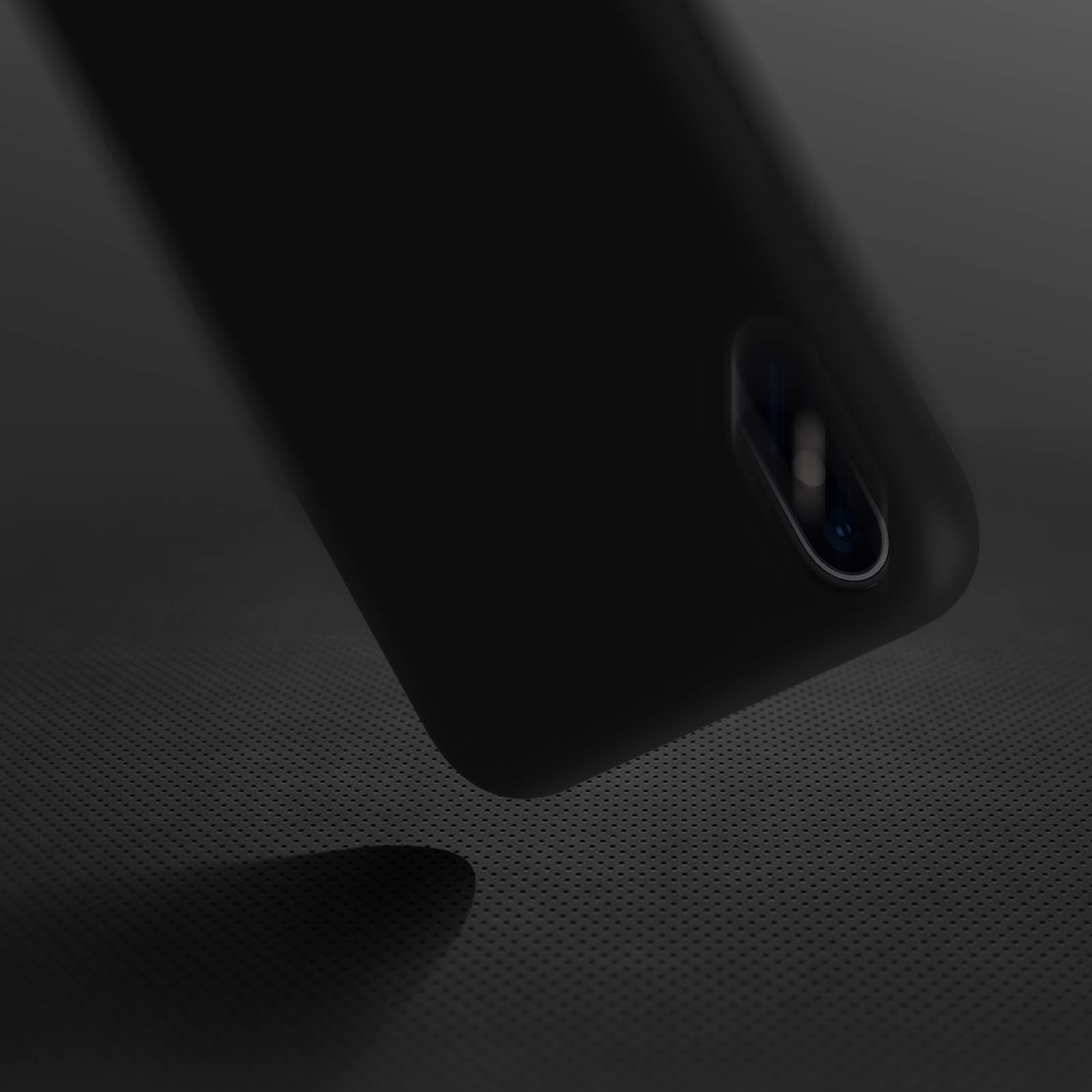 Custodia nera per telefono su una superficie scura. Obiettivo della fotocamera visibile. Sfondo nero.