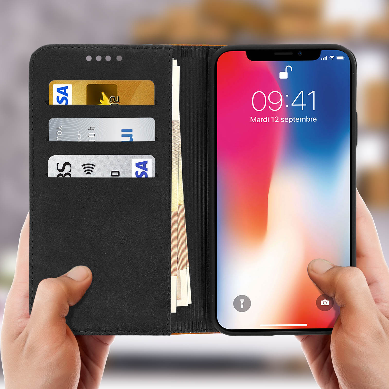 Mani che tengono una custodia per telefono nera aperta, rivelando un telefono. Carte e denaro sono visibili.