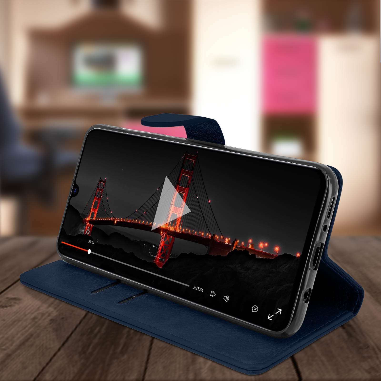 Téléphone affichant une vidéo du Golden Gate, sur une table en bois. Le téléphone est dans un étui bleu.