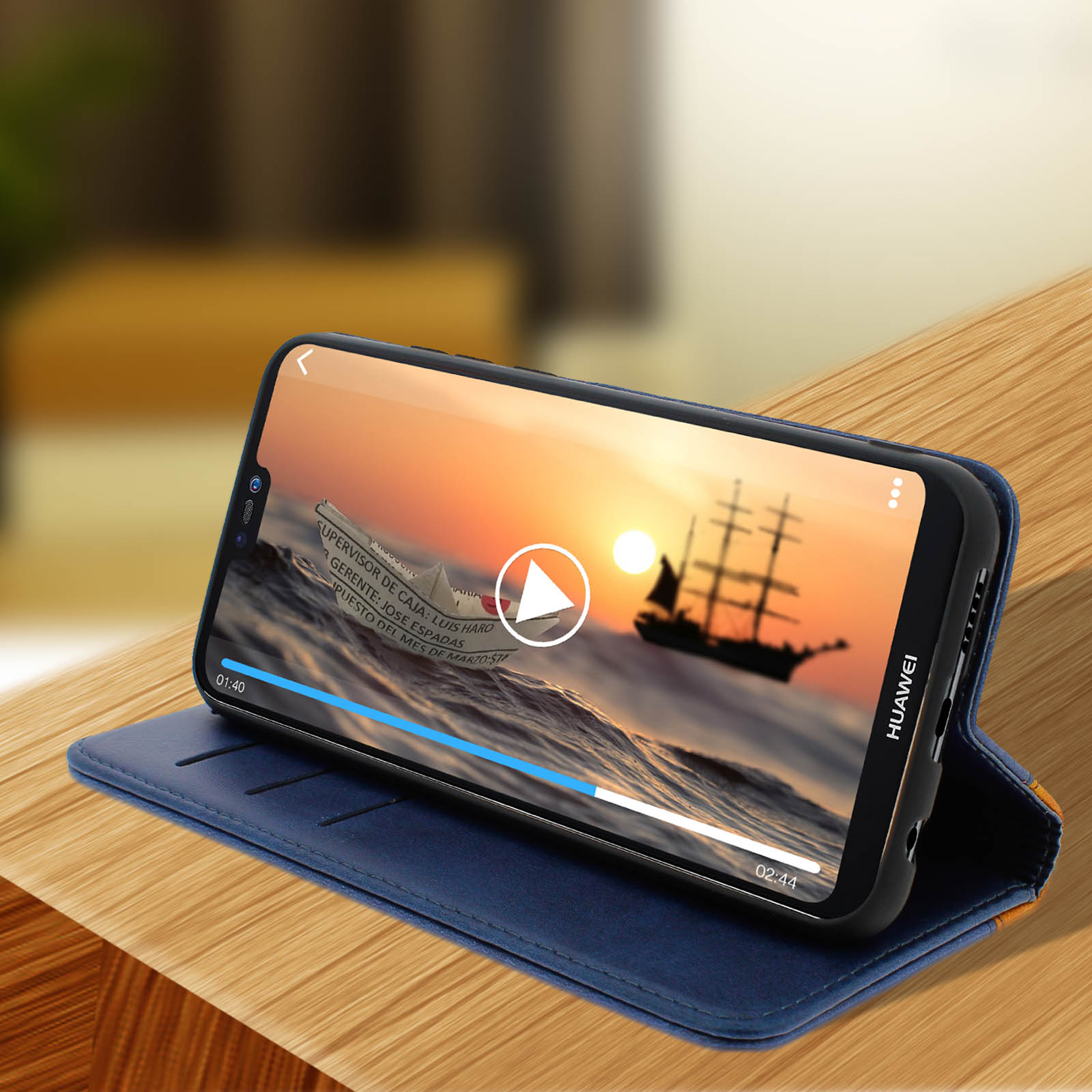 Custodia per telefono blu con telefono che mostra un video. Il telefono è appoggiato su una superficie di legno.