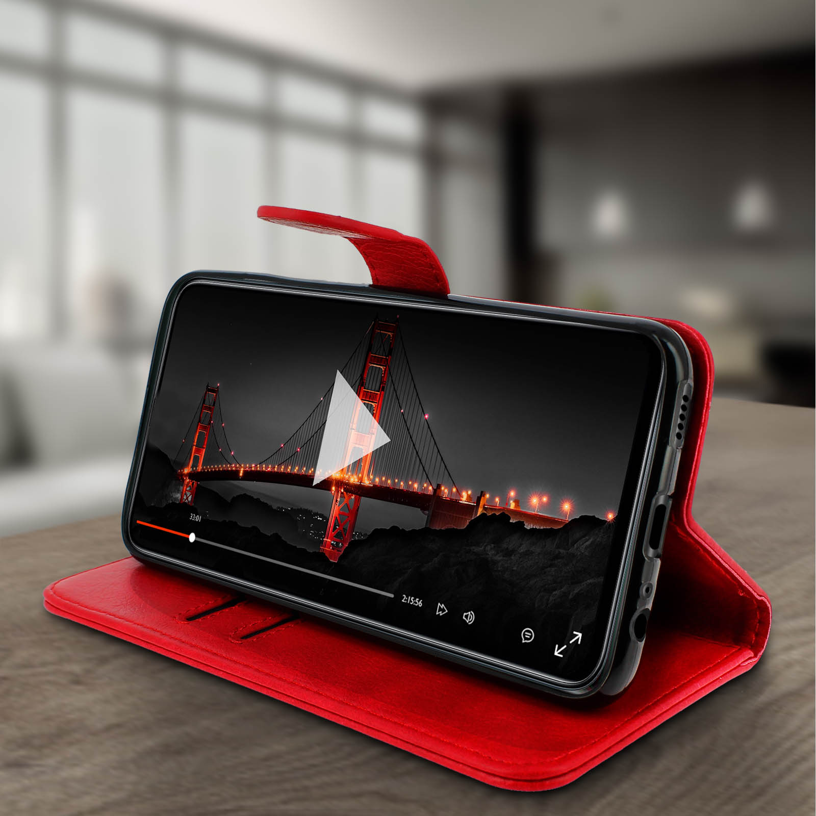 Coque de téléphone rouge. Le téléphone affiche une vidéo du Golden Gate. L'étui est ouvert.