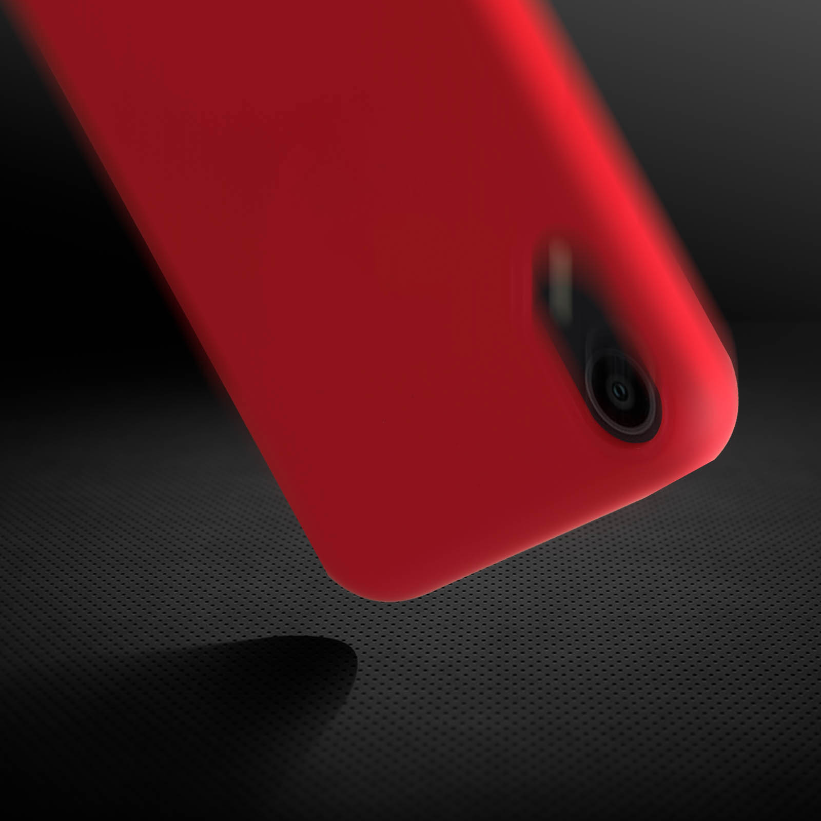 Coque de téléphone rouge, gros plan. Montrant l'objectif de la caméra et un fond sombre texturé.