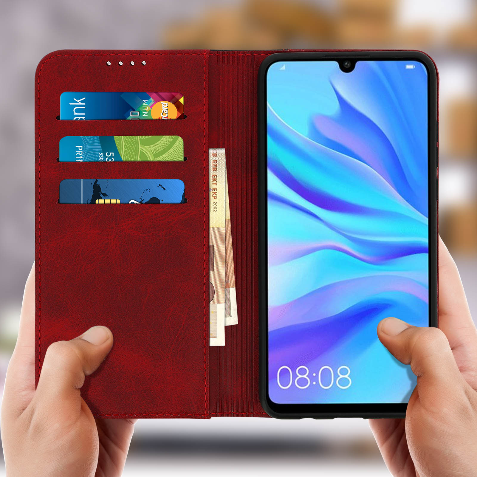 Un telefono in una custodia a portafoglio rossa. La custodia è aperta, mostrando carte e denaro.