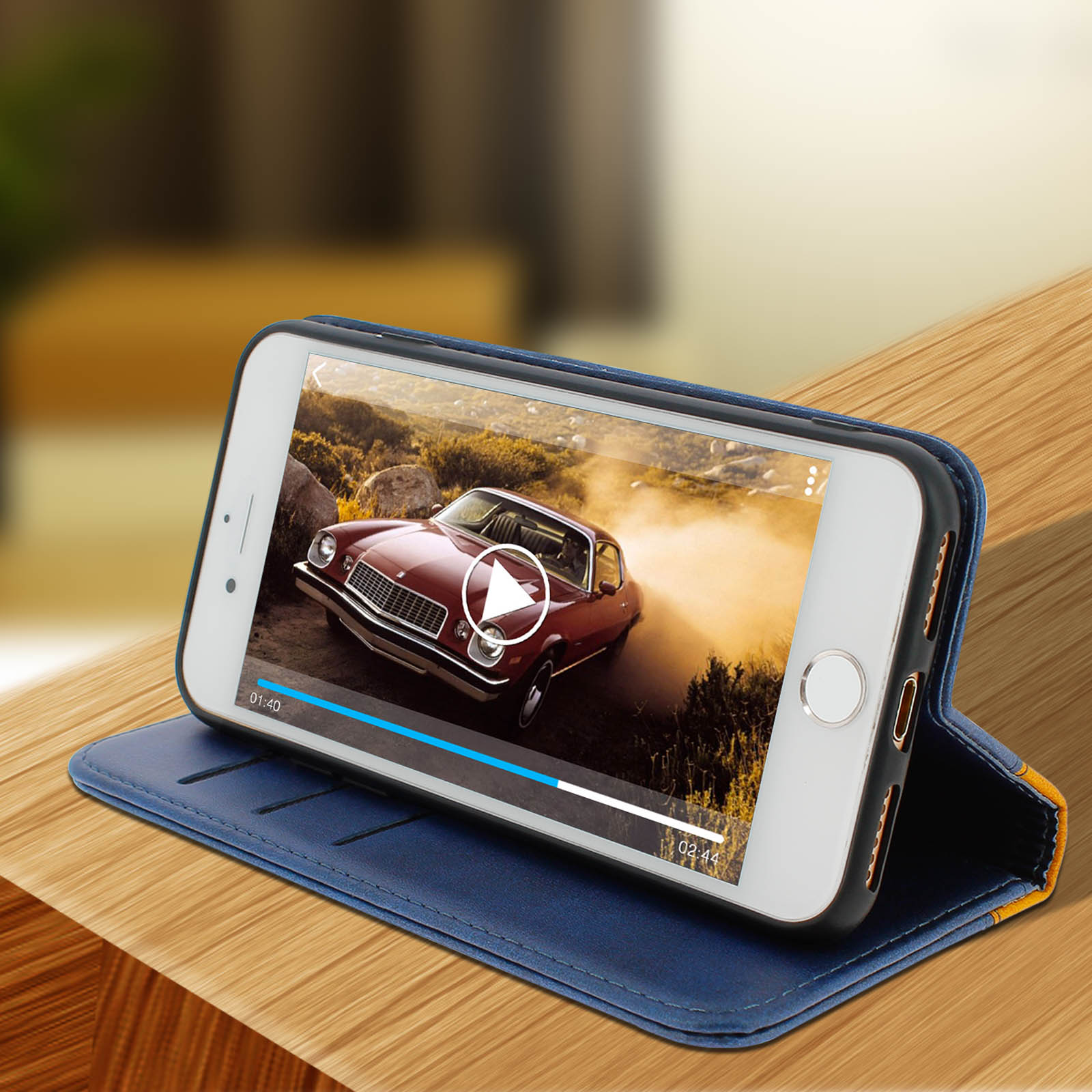Un telefono in una custodia blu mostra un video di un'auto. Il telefono è su una superficie di legno.