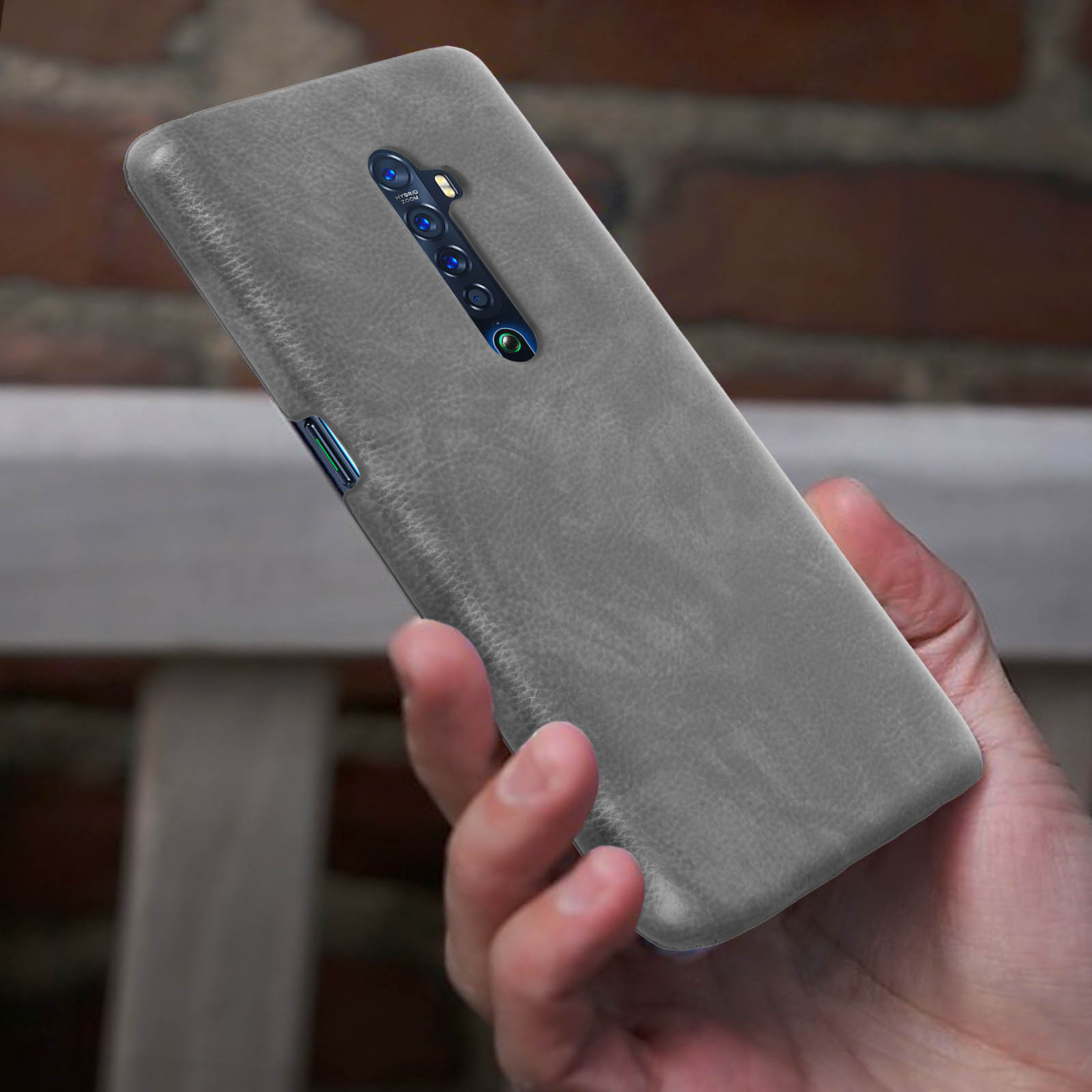 Una mano che tiene un telefono grigio con un retro simile alla pelle.