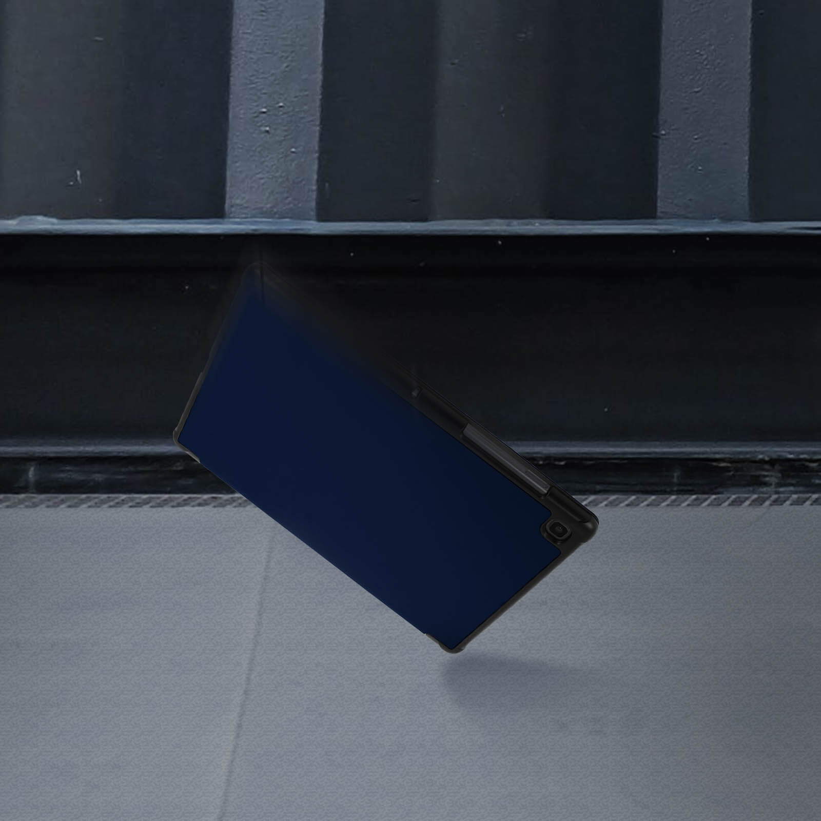 Un tablet con schermo blu cade, circondato da uno sfondo scuro.