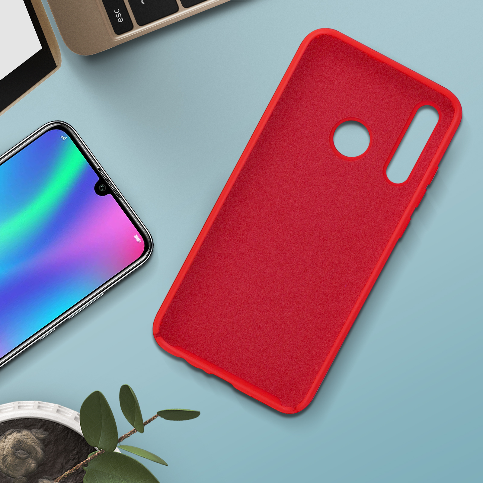 Étui de téléphone rouge et téléphone sur une table, avec des feuilles dans le coin.