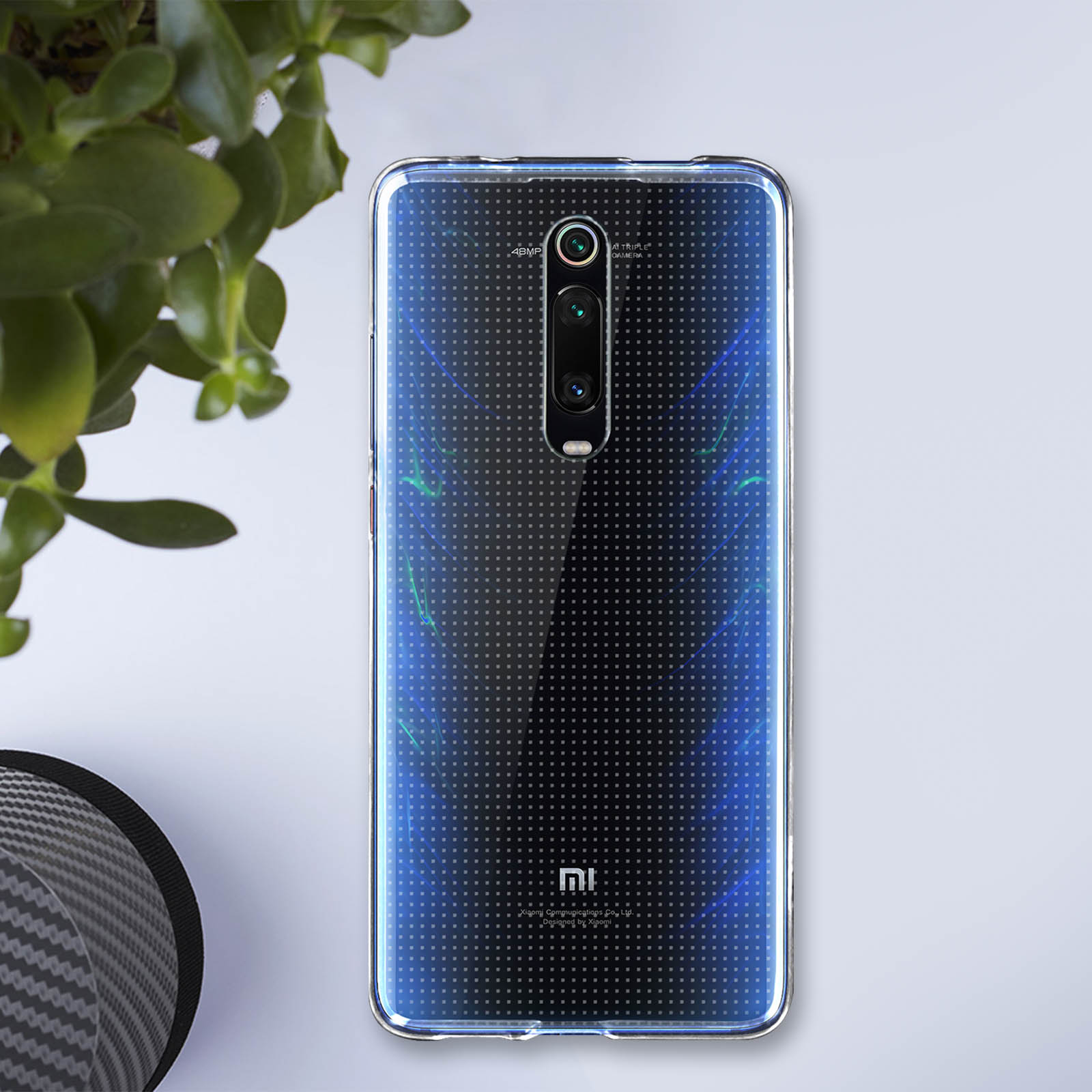 Téléphone avec une coque transparente. Le dos présente un motif de points avec un dégradé bleu.