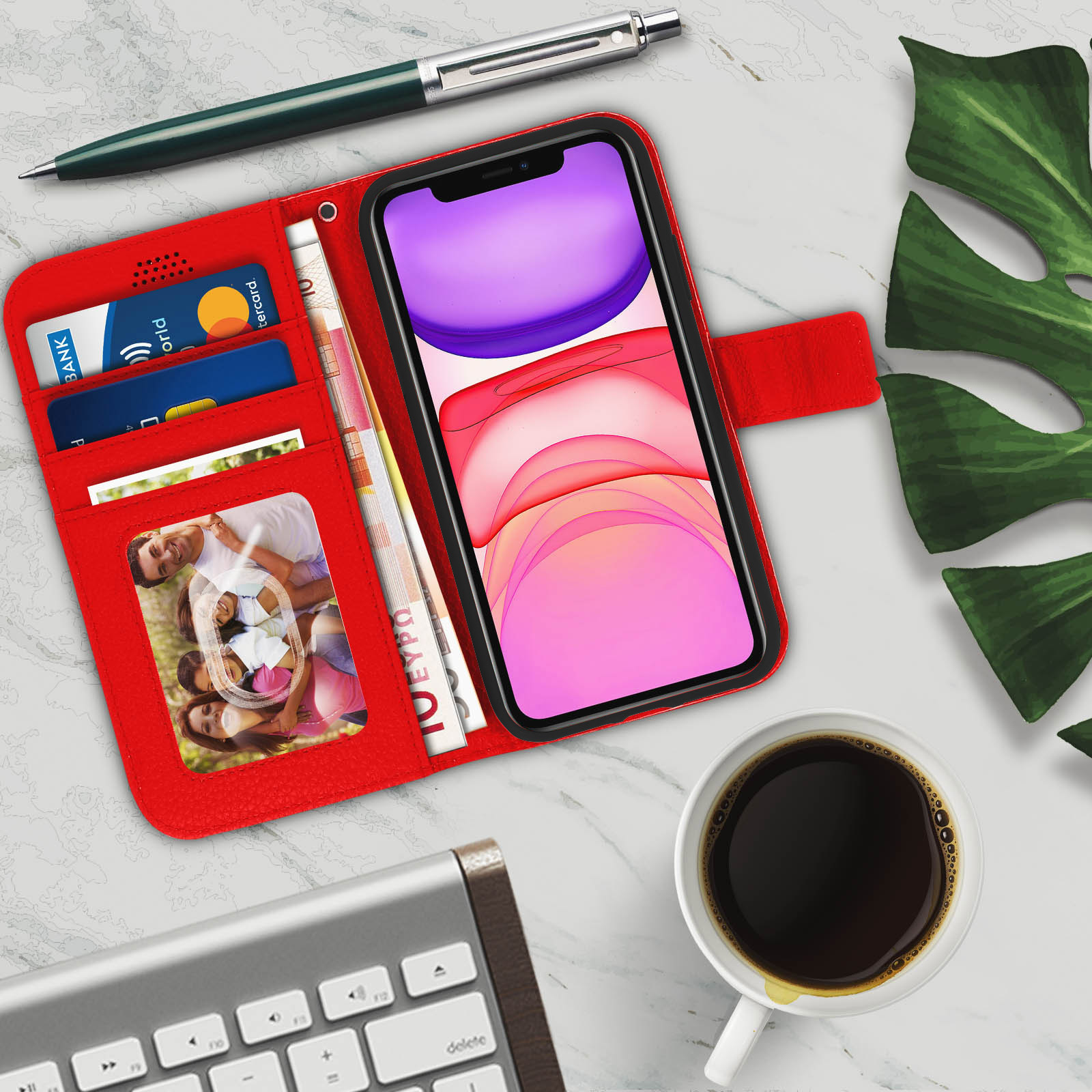 Custodia per telefono rossa aperta con scomparti per carte, denaro e una foto. Sono visibili una penna e una tastiera.