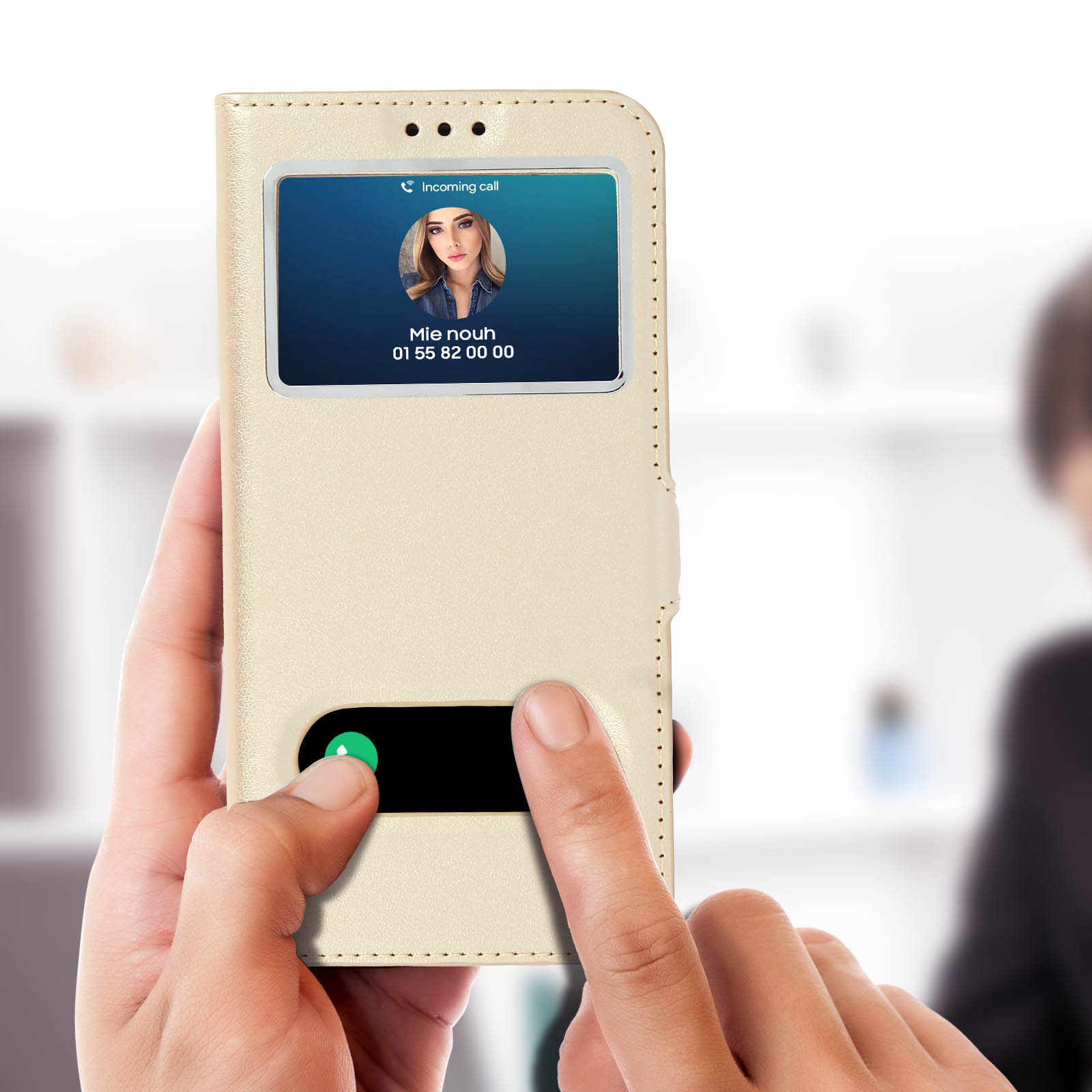 Una custodia dorata per telefono con uno schermo che mostra una chiamata in arrivo da una donna. Un dito tocca lo schermo.
