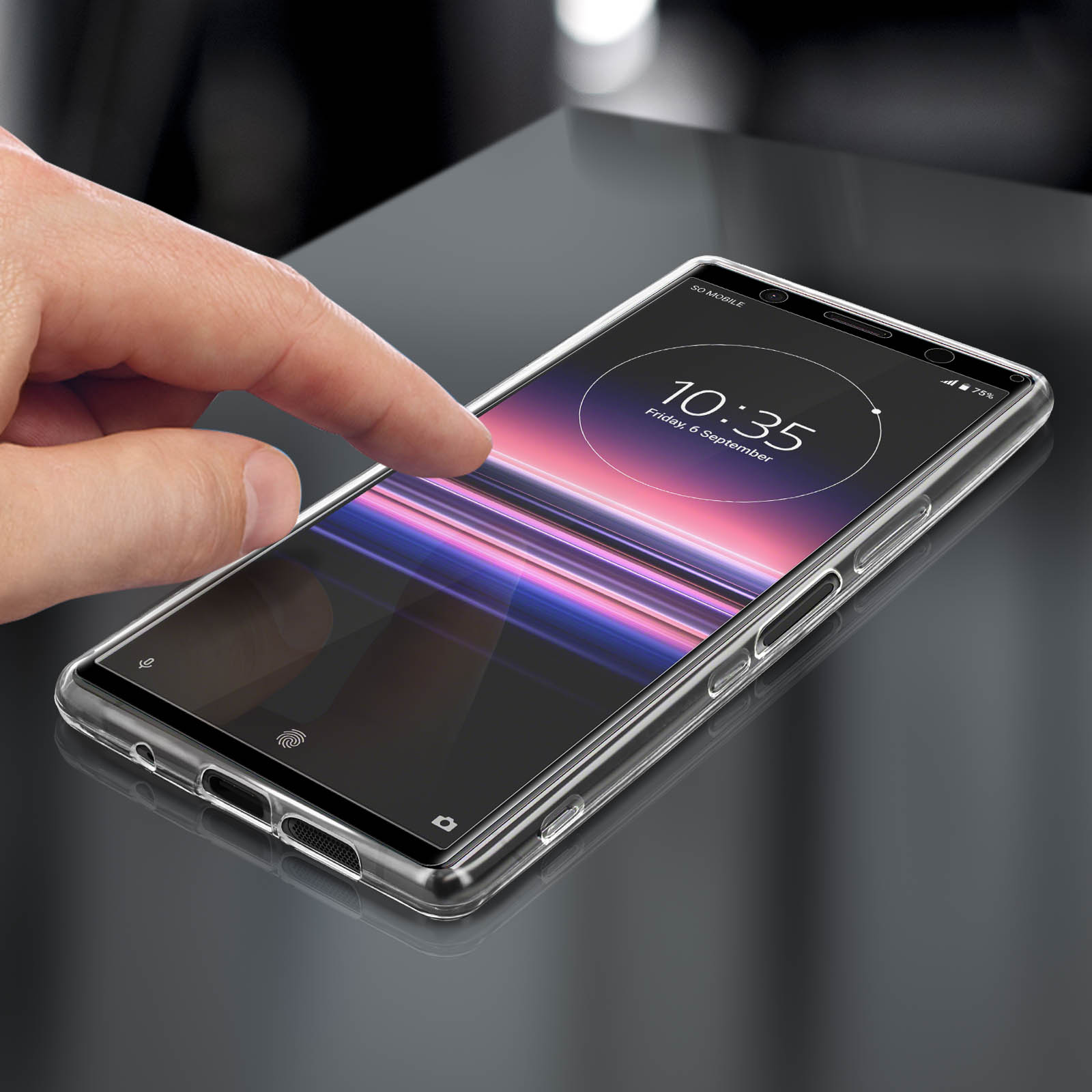 Une coque de téléphone transparente sur une surface noire, avec un doigt touchant l'écran.