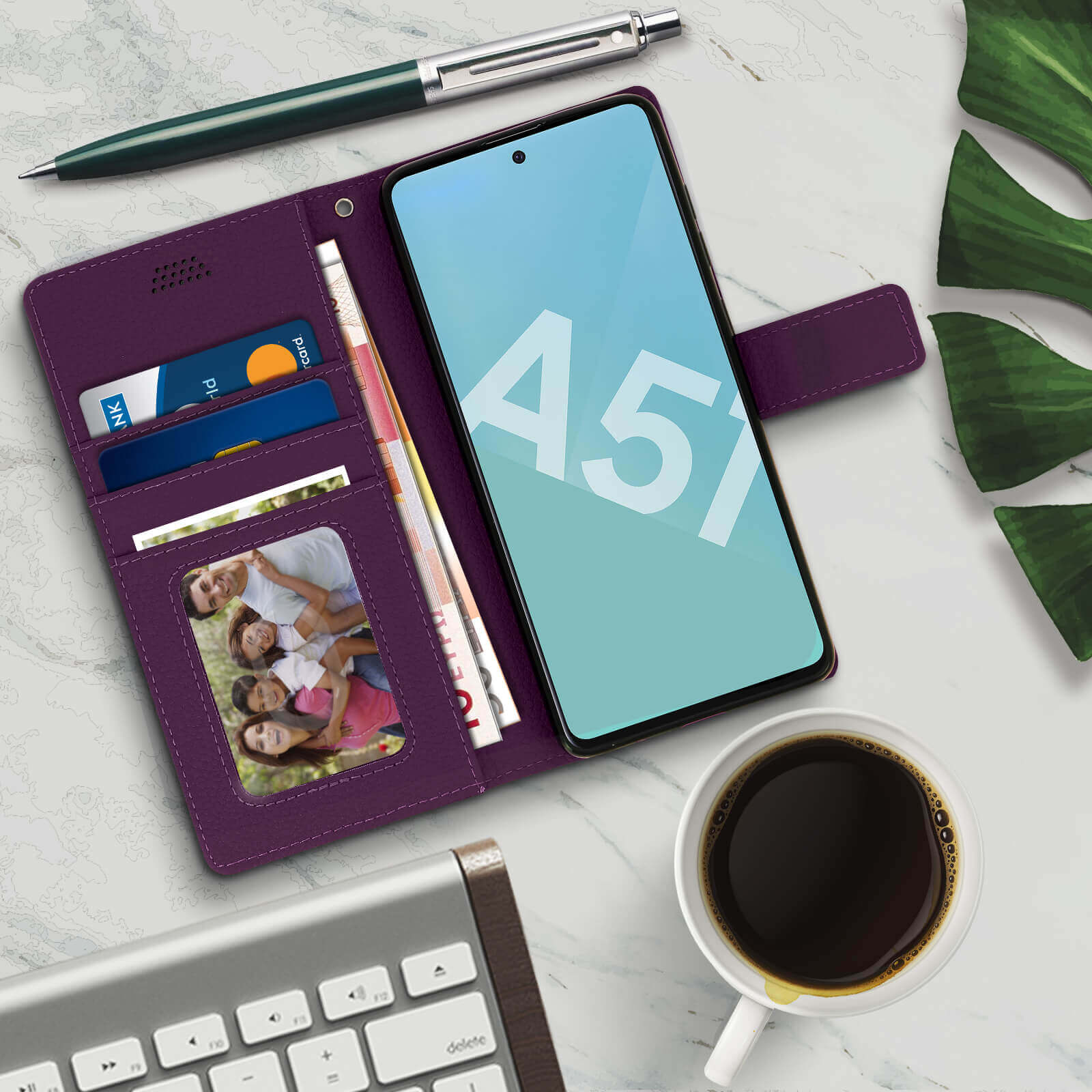 Étui de téléphone violet, téléphone avec écran, argent, cartes, stylo et café sur table en marbre.