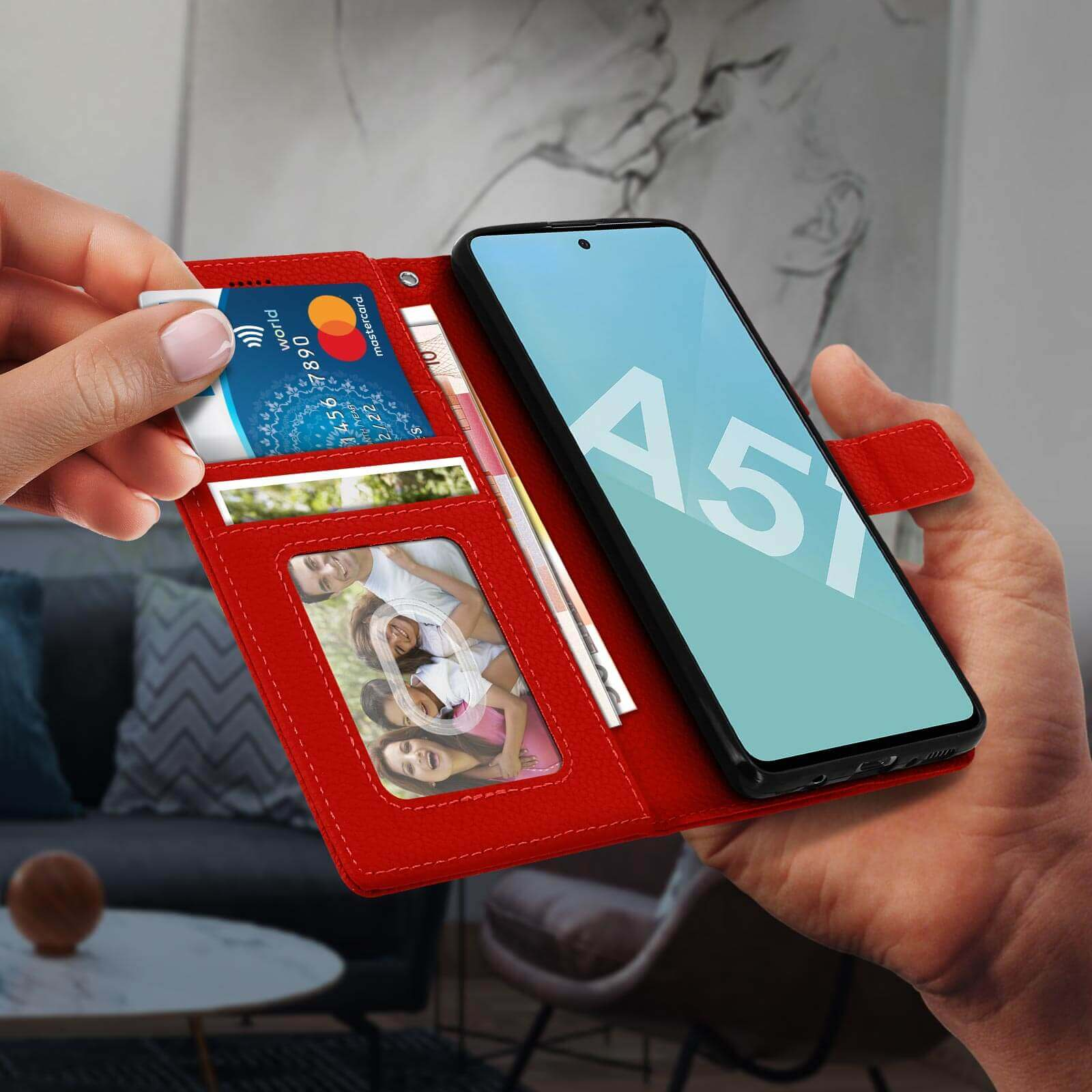 Un téléphone dans un étui portefeuille rouge avec cartes de crédit, photos et argent visibles.