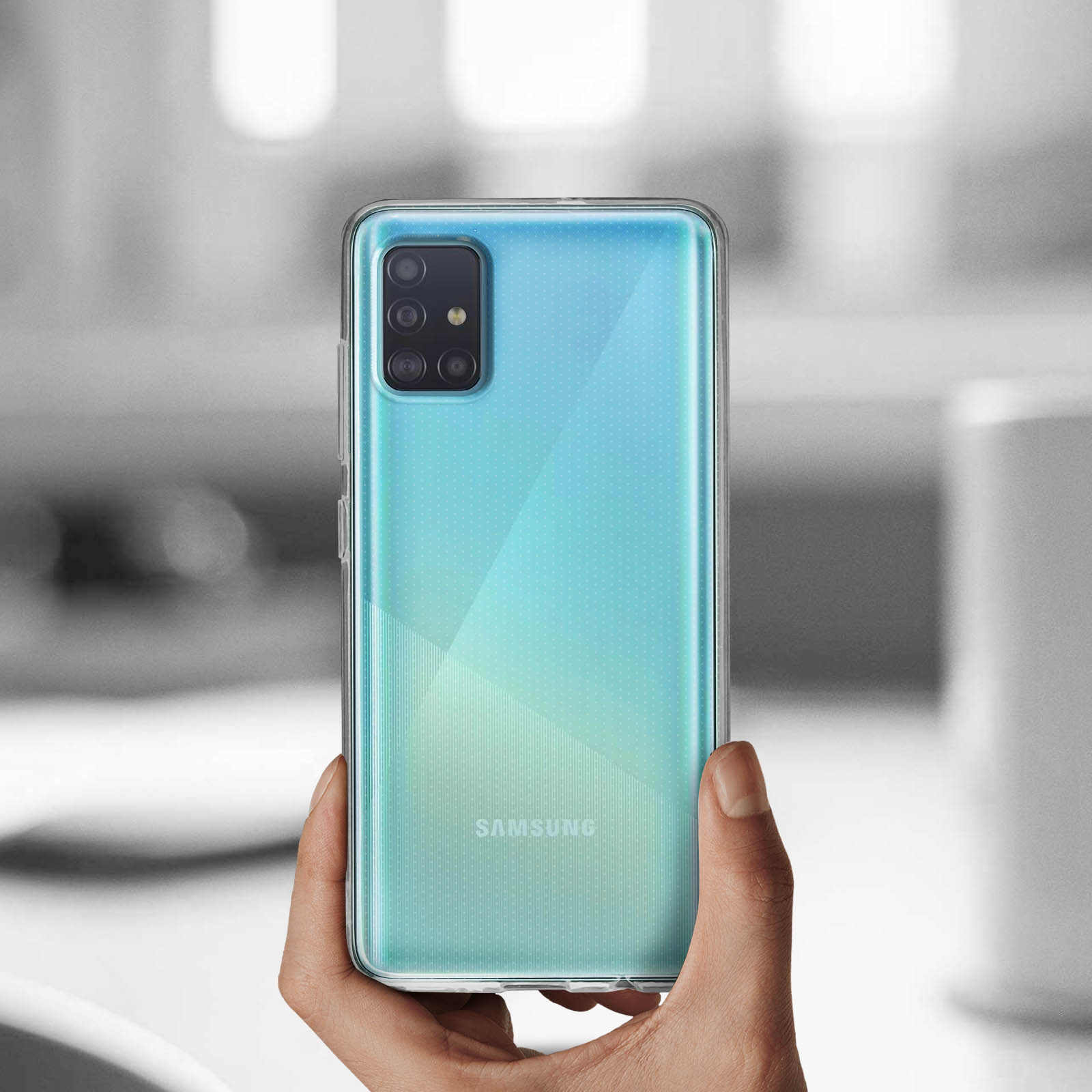 Mano che tiene un telefono in una custodia trasparente. Il telefono è di colore blu-verde. La custodia è trasparente.