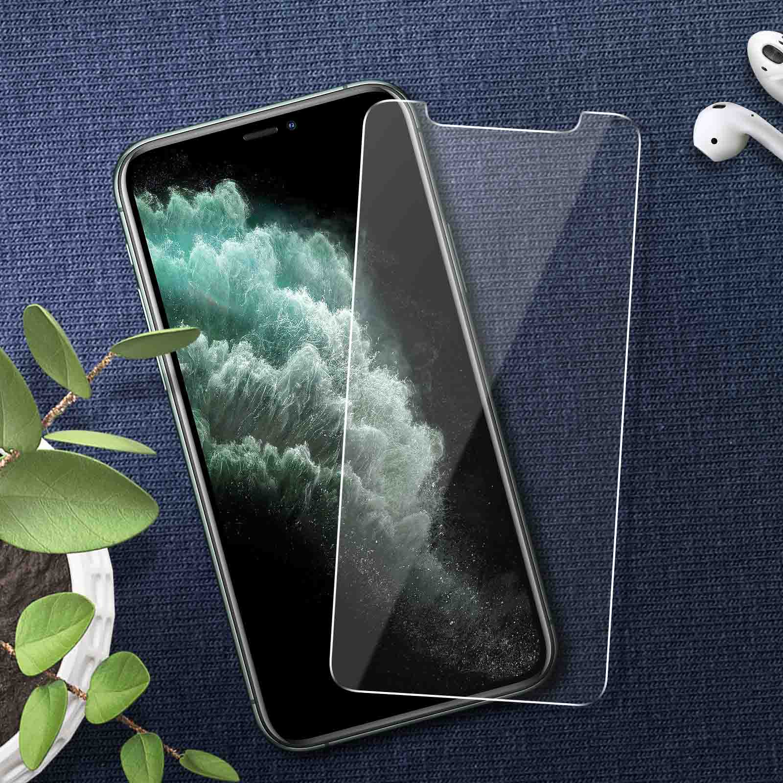 Phone with a screen protector and earbuds on a dark blue patterned surface.