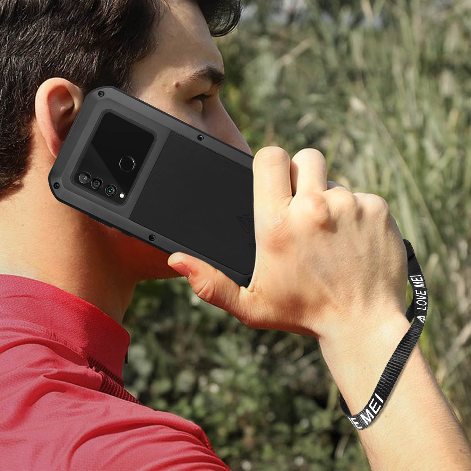 Un uomo che tiene un telefono in una custodia nera all'orecchio.