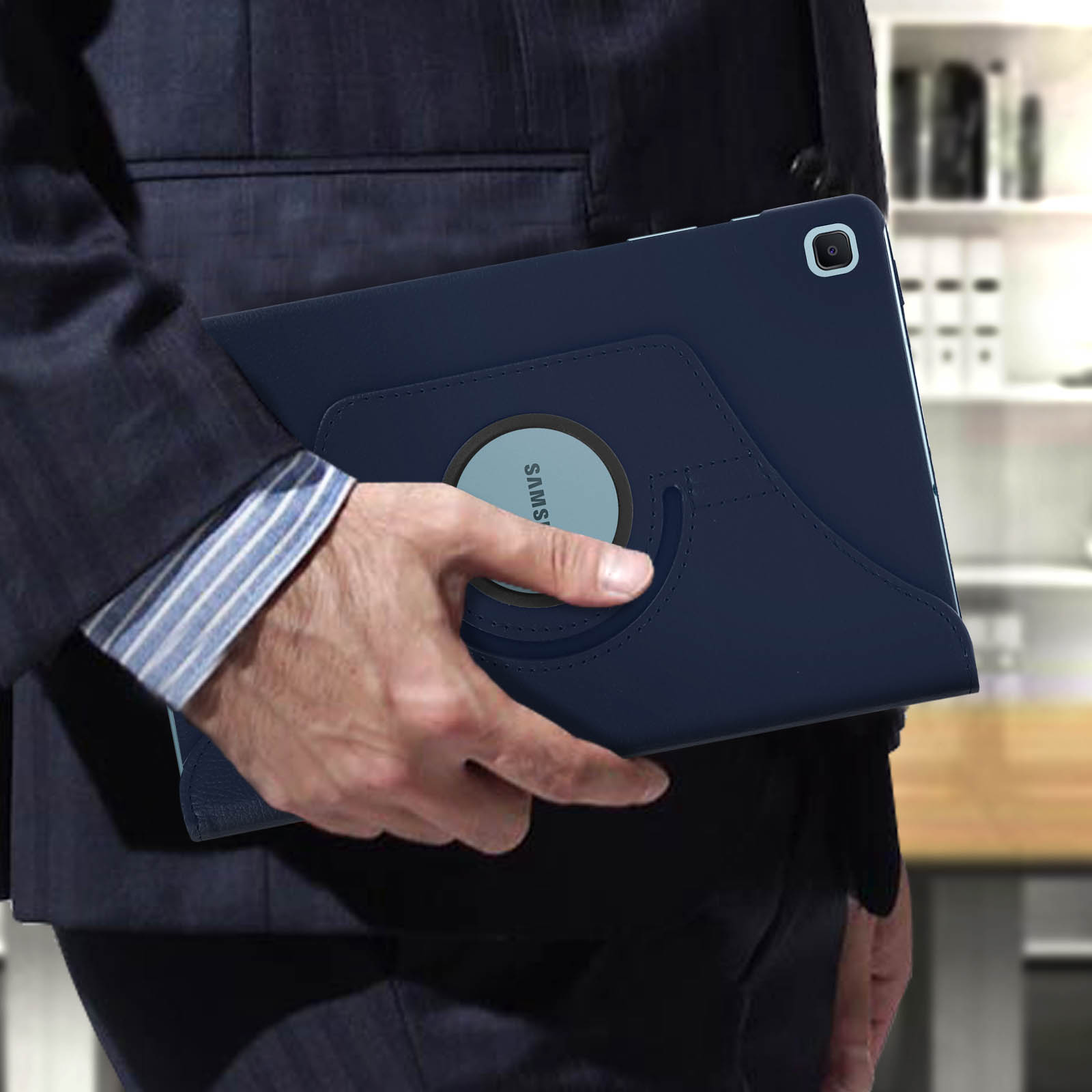 Un uomo in giacca e cravatta tiene in mano un tablet blu in una custodia. La custodia sta ruotando.