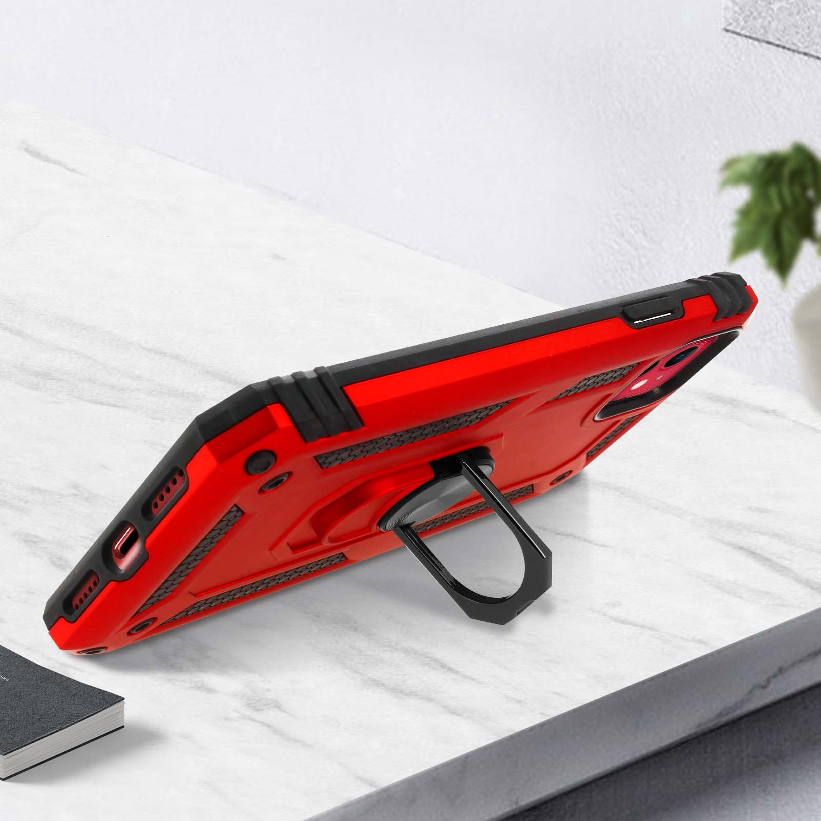 Custodia rossa con anello nero. La custodia poggia su una superficie bianca.