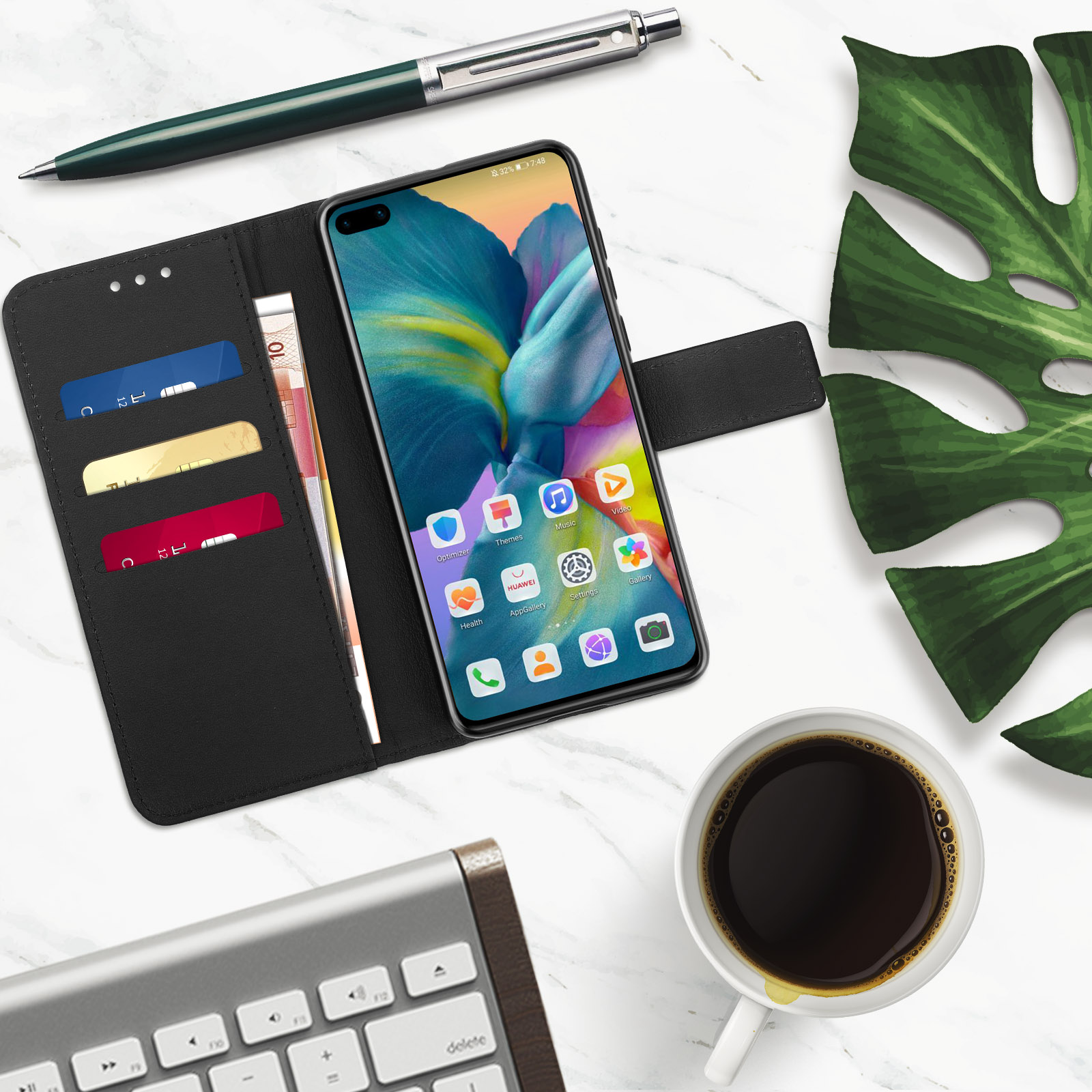 Telefono in custodia nera, carte e denaro, penna, tazza di caffè e foglia su superficie di marmo.