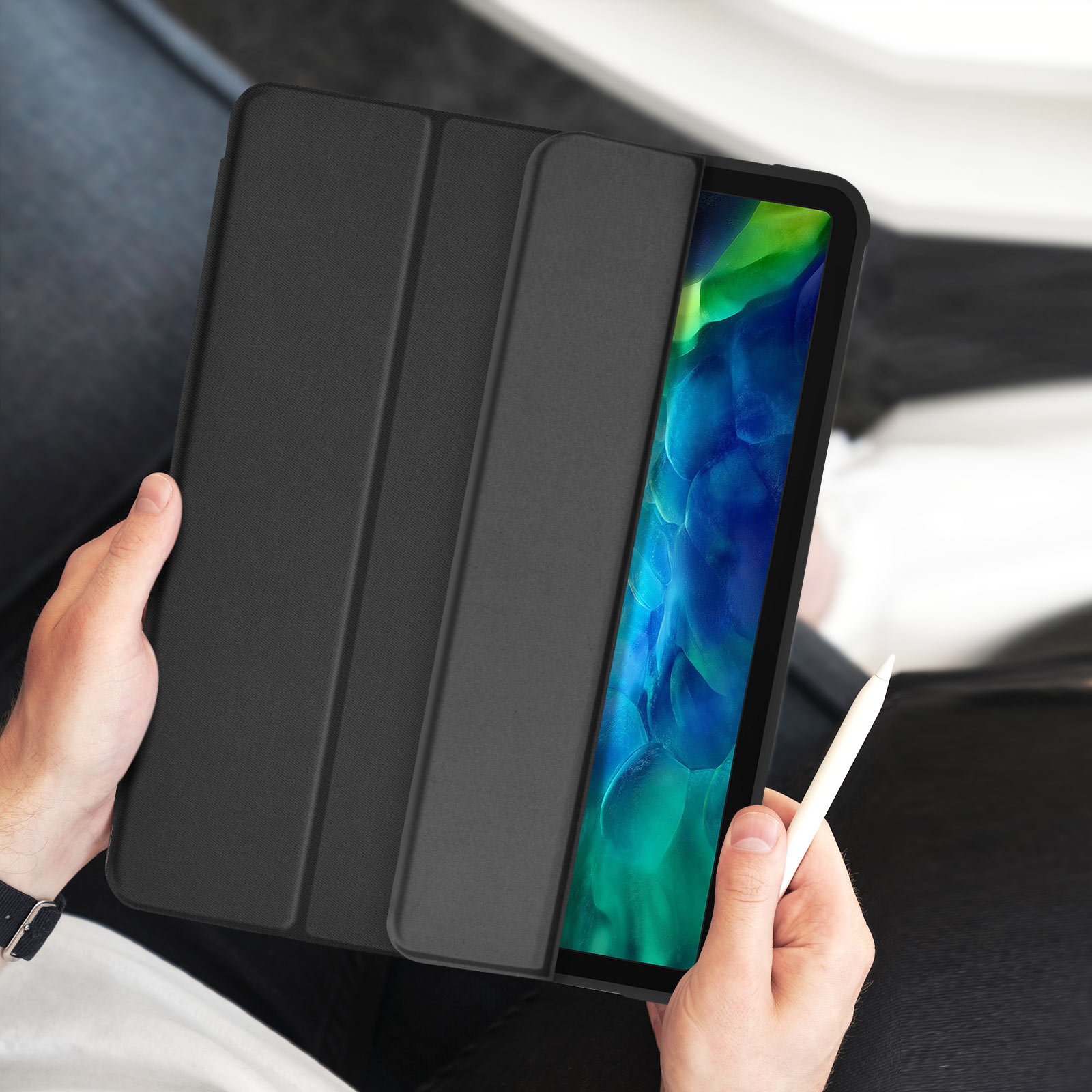 Tablet in custodia nera tenuto tra le mani. Il tablet è a fuoco, con uno stilo.
