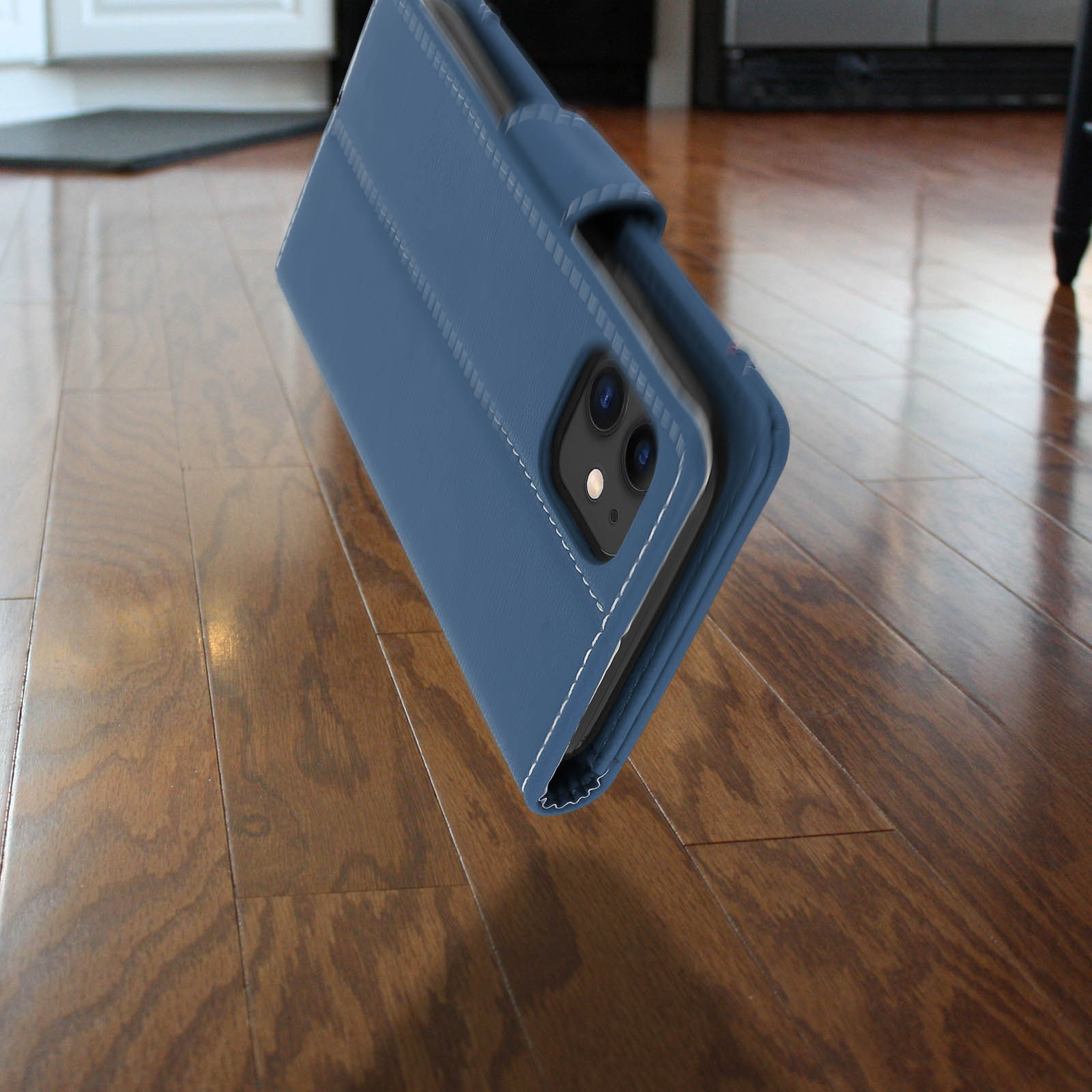 Custodia blu per telefono appoggiata su un pavimento in legno. La custodia ha un telefono all'interno.