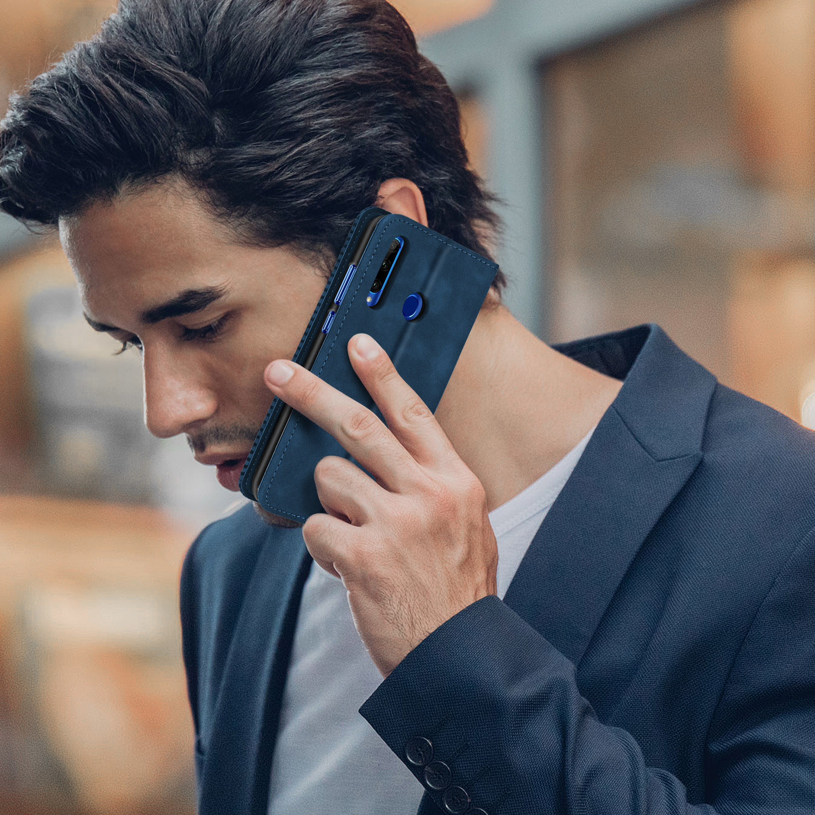 Uomo che tiene un telefono all'orecchio. Custodia blu.