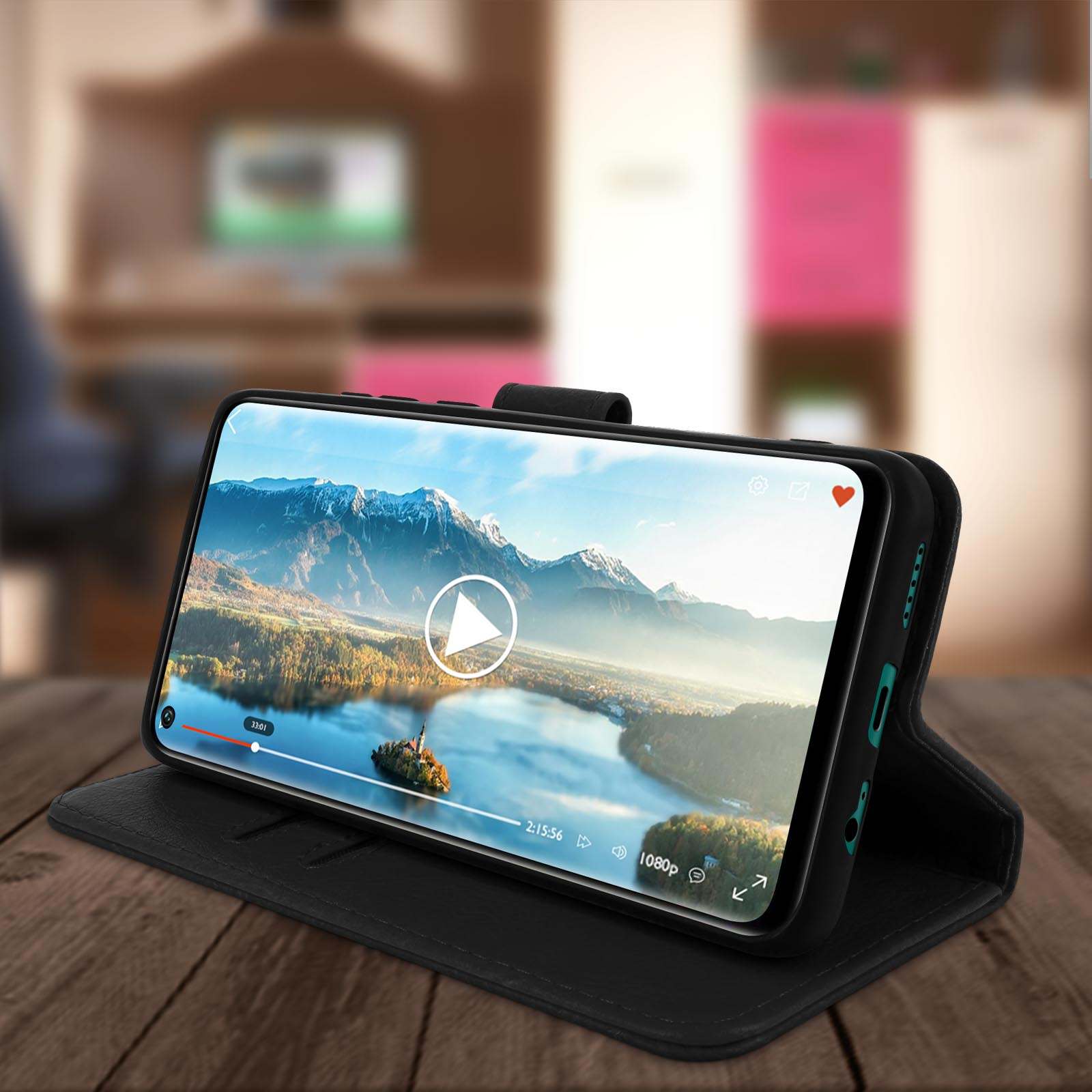 Un téléphone noir affichant une scène de rivière est dans un étui noir, ouvert sur une table en bois.