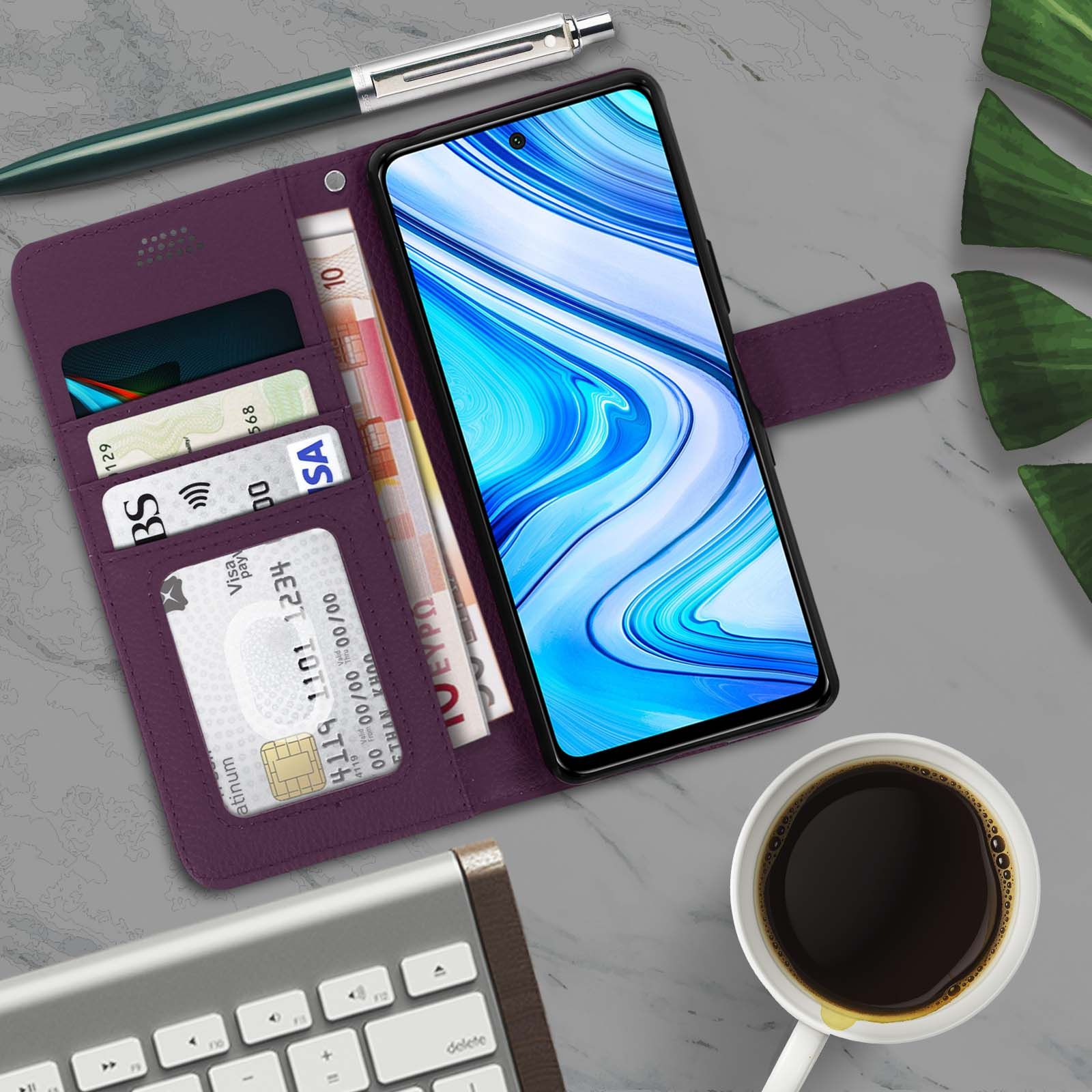 Un téléphone dans un étui portefeuille violet avec des cartes, de l'argent et une tasse de café sur une surface grise.