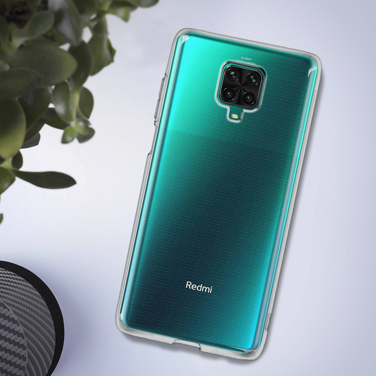 Une coque transparente avec un téléphone à dégradé vert. La coque est devant une plante.