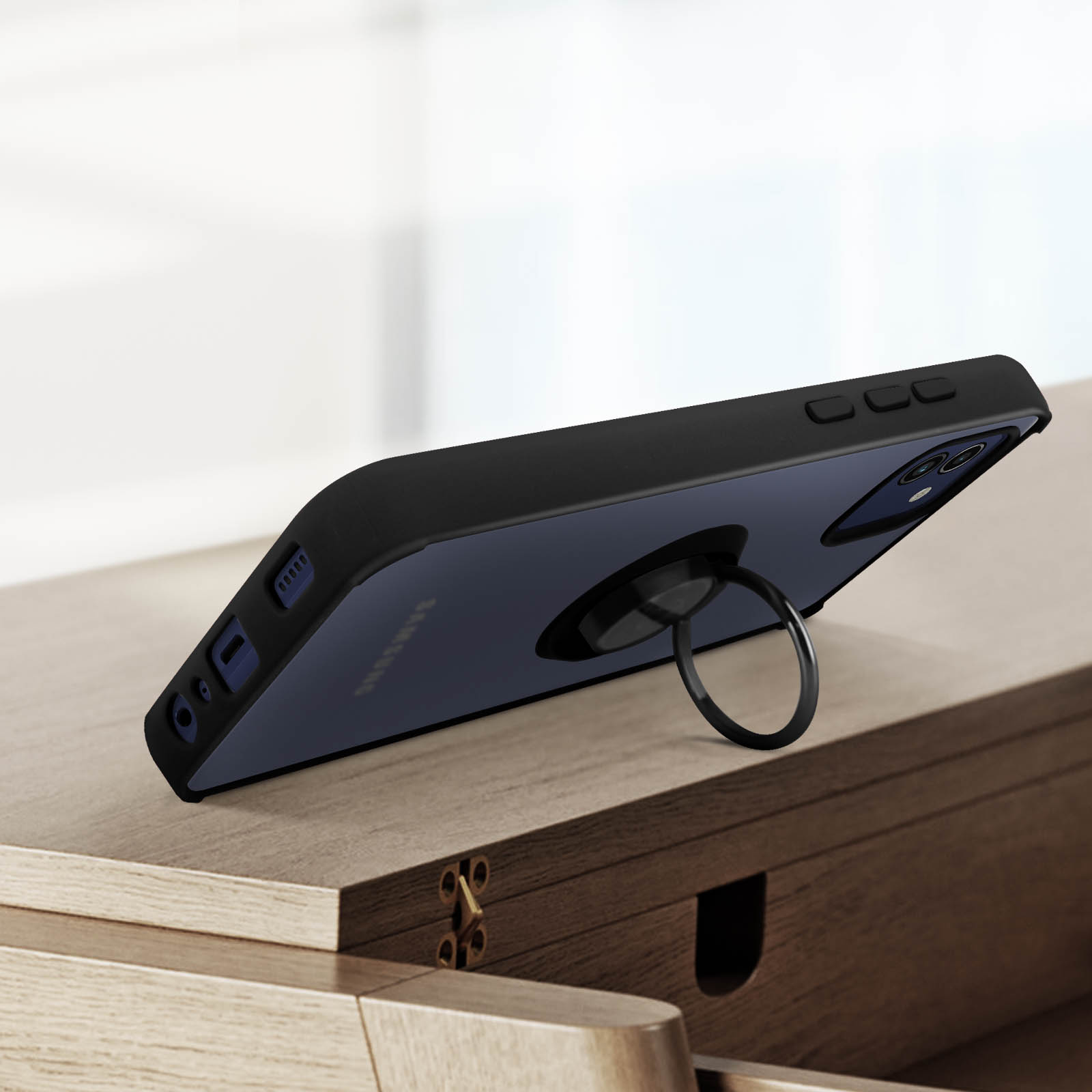 Een zwarte telefoonhoes met een ringhouder op een houten oppervlak. De telefoon is zwart.