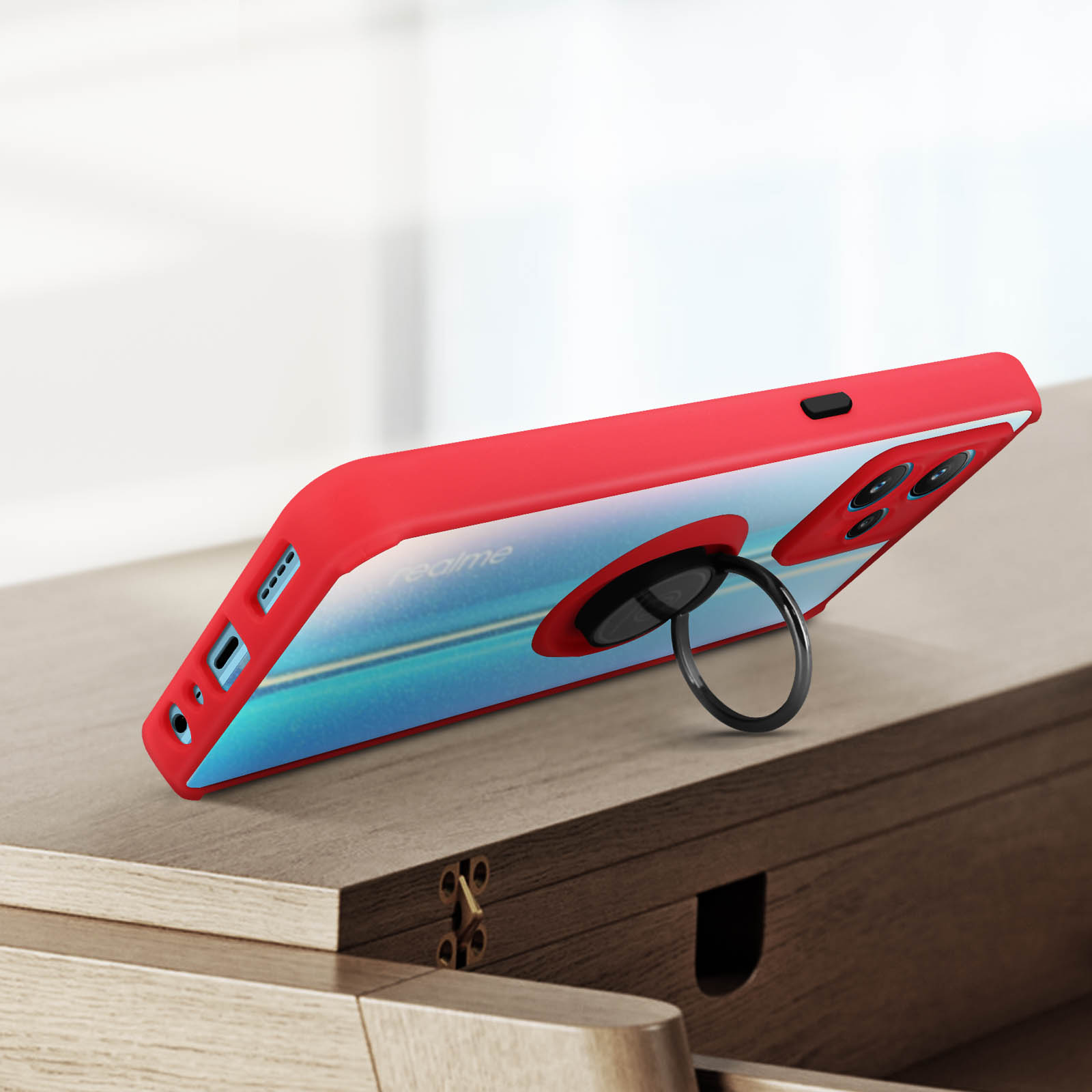 Custodia rossa con supporto ad anello su superficie in legno. Telefono angolato.