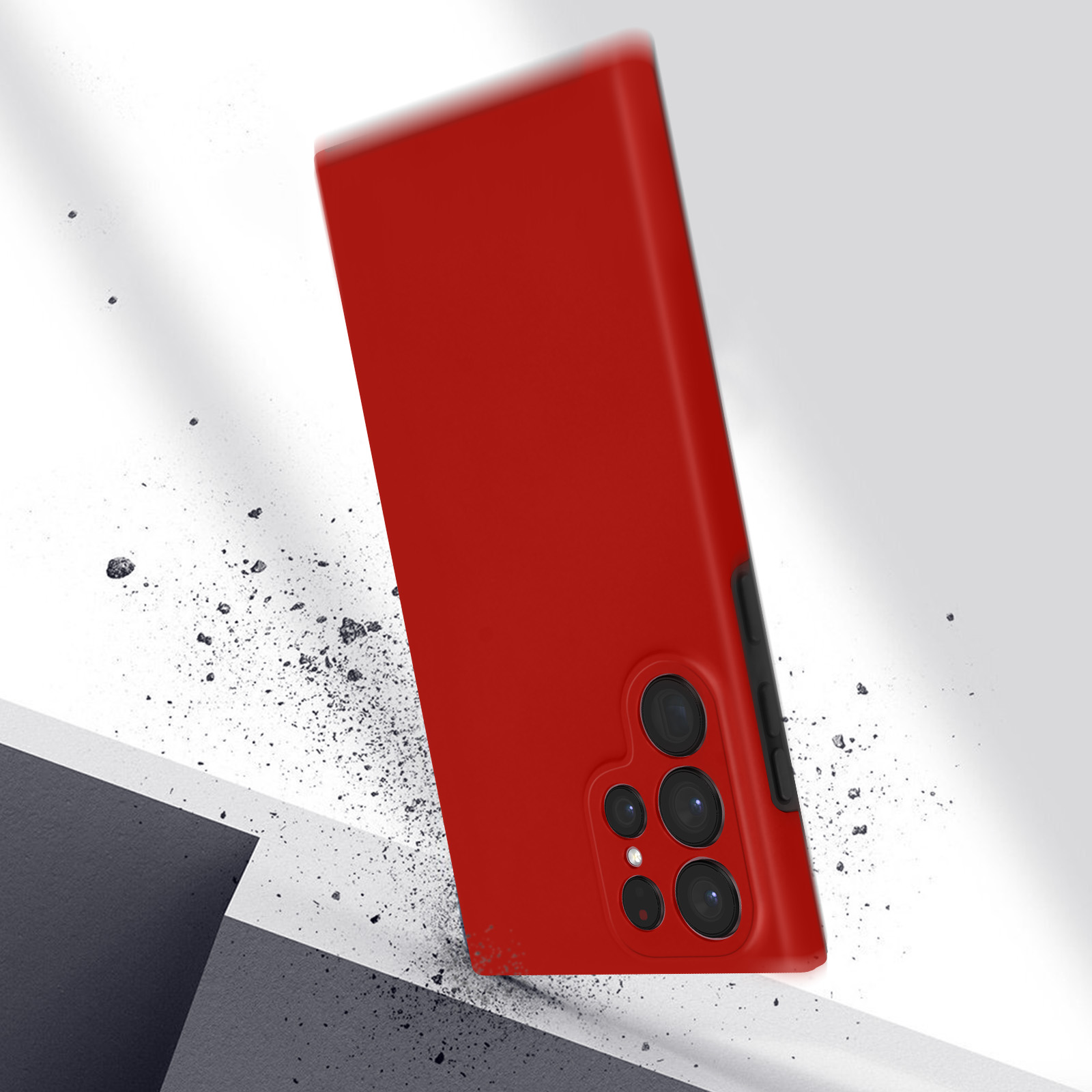 Coque de téléphone rouge tombant. Petits débris, fond gris, prise de vue en angle.